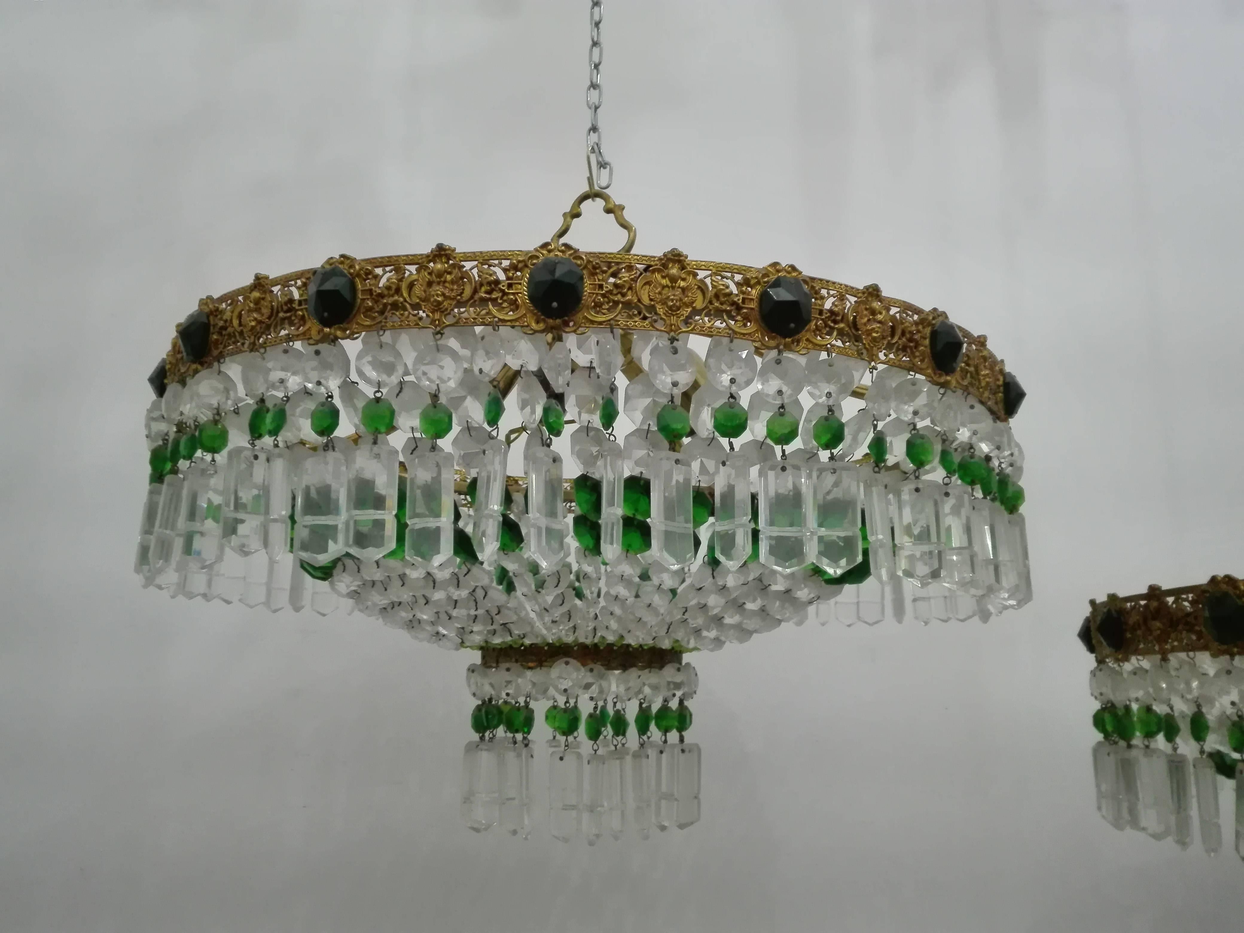 Pair of ceiling lights with green and transparent crystals with brass band worked with angels and dragons missing only a pendant as pictured (see photo) ceiling light with four-light points
Dimensions:
diameter 55 cm
height 45 cm.