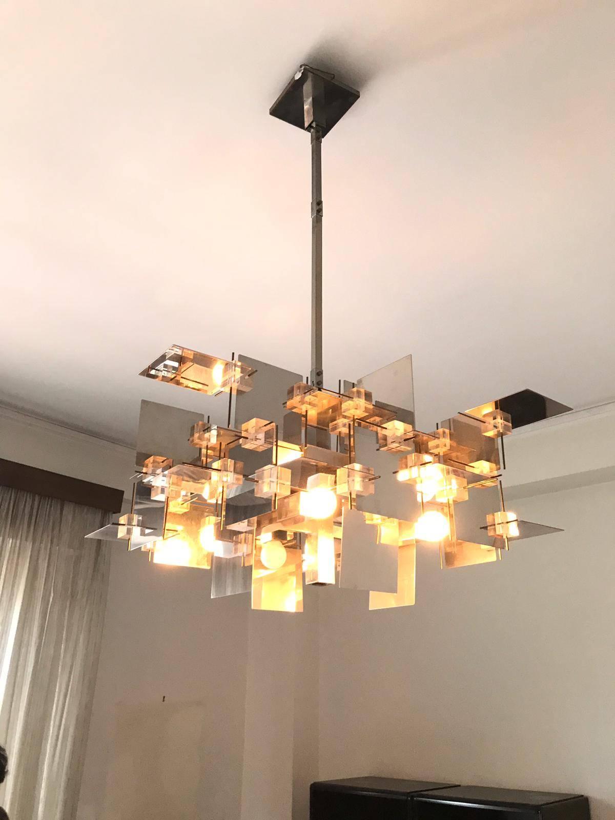 Large and rare 12 lights chandelier in polished chrome with cubes and plexiglass panels and brass temples designed by Gaetano Sciolari.