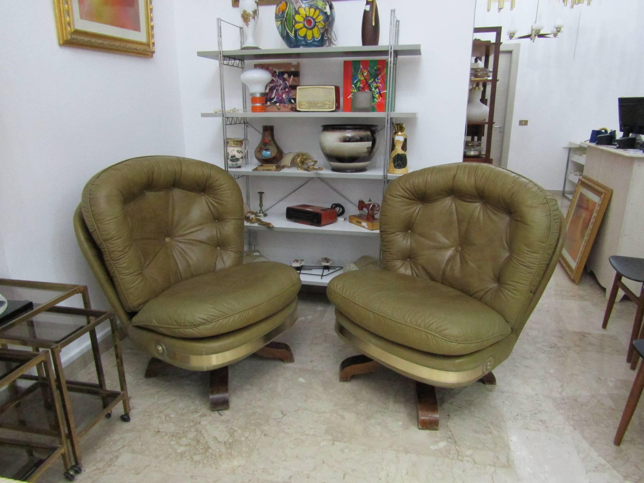 Pair of majestic design armchairs in vintage Italian leather covers. Leather armchairs with wooden base and brass band (to be cleaned).