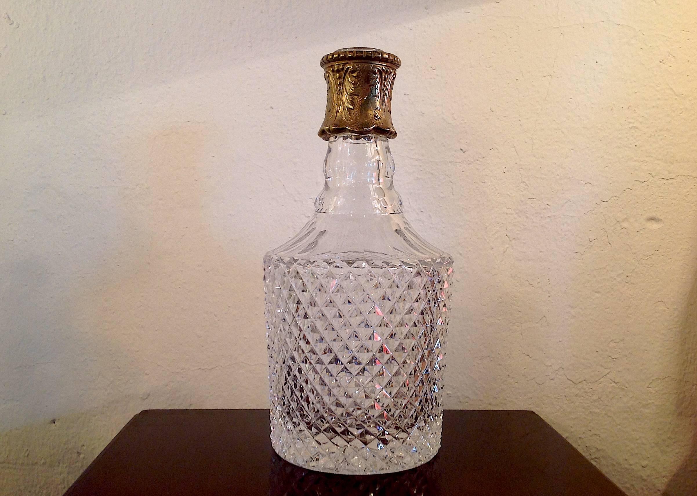Vintage fine cut crystal decanter with mounted brass neck, with stopper, measures 12 inches high and 5 inches wide.