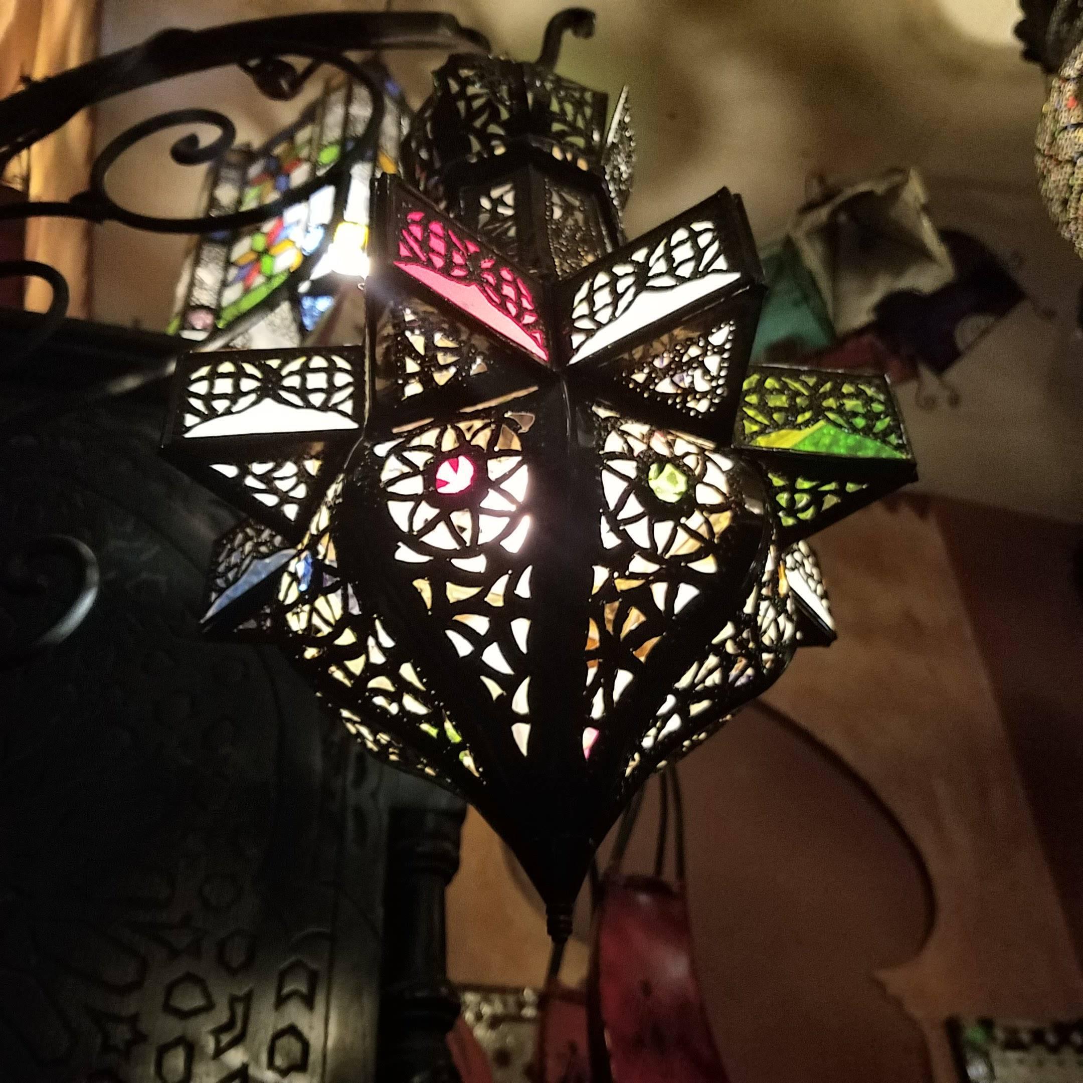 Small size Moroccan pierced metal lantern, star design with small multicolor glass fragments on a copper stained frame, measuring approximately 18? in height and 10