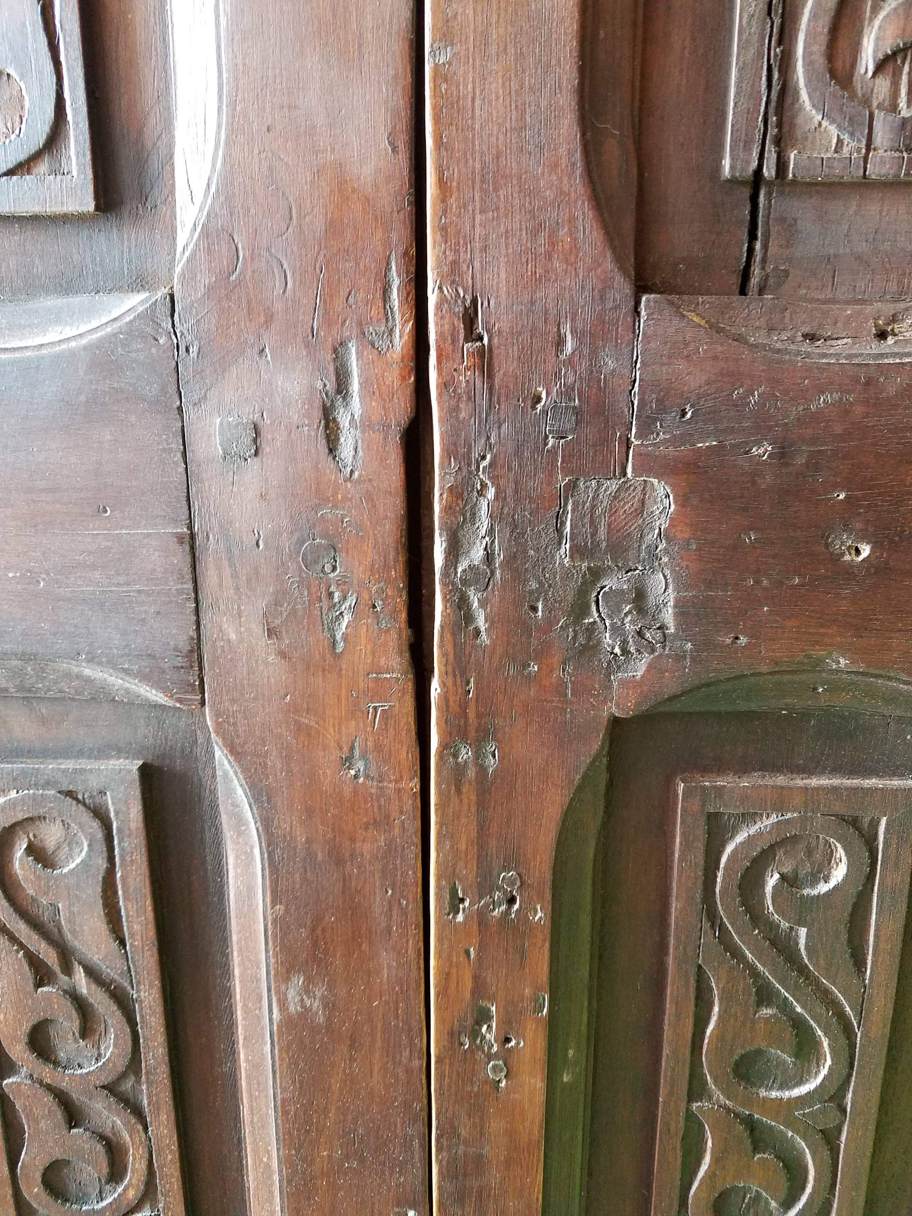 This is a beautiful old Moroccan double-panel wooden door from early 1900s. Over 100 years old, but the exact date this door was made is unknown. Comes from an old Riad in Rabat that was recently refurbished. Mediterranean scroll carvings
