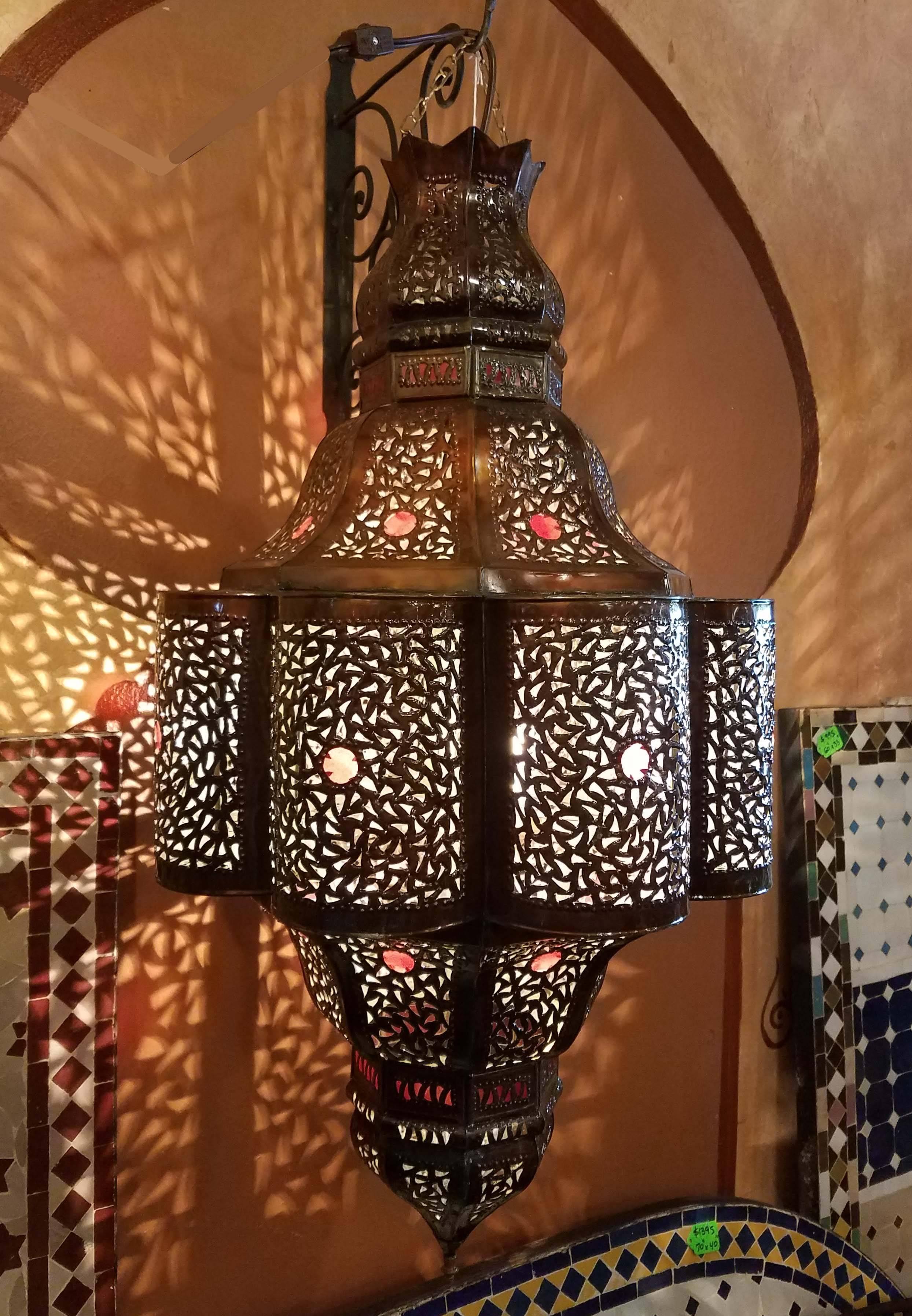 Large size Moroccan pierced metal lantern, living style with small red-color glass fragments on a copper stained frame, measuring approximately 33