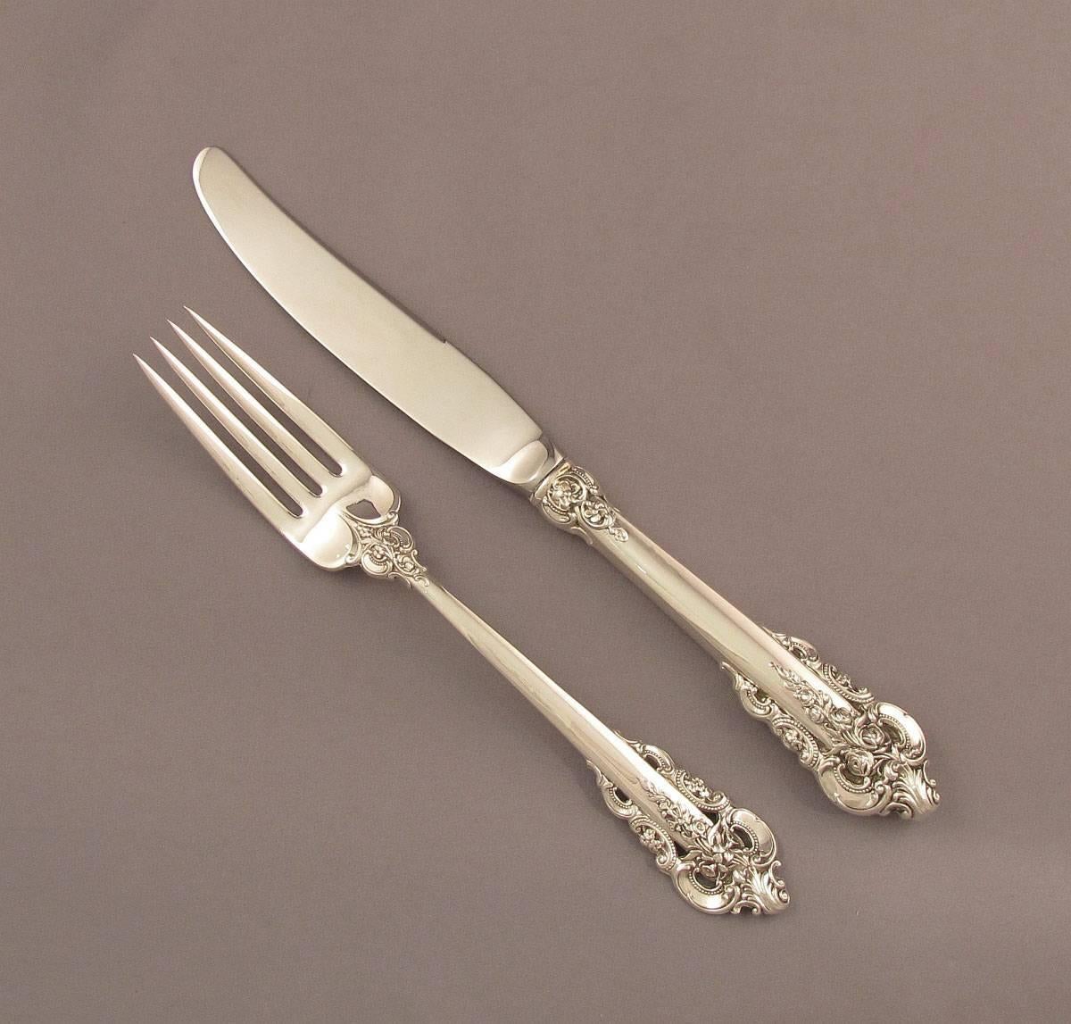 An extensive Wallace Grande Baroque sterling flatware service for 12 comprising:

12 dinner knives.
12 dinner forks.
12 luncheon knives.
12 luncheon forks.
12 butter spreaders.
12 salad forks.
12 oyster forks.
12 dessert spoons.
12 cream