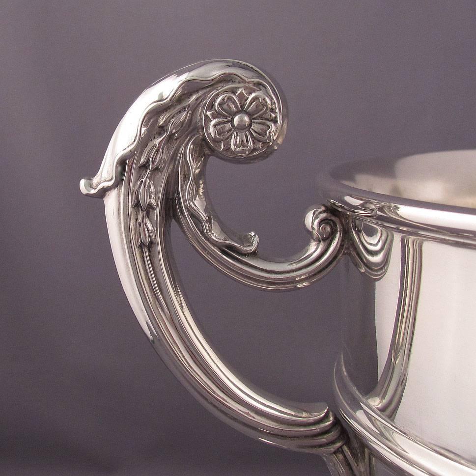 A massive Edwardian silver punch bowl, hallmarked London 1908 by Goldsmiths & Silversmiths Co., in the George II style with acanthus capped double scroll handles and cut card strap-work. Presented as the 