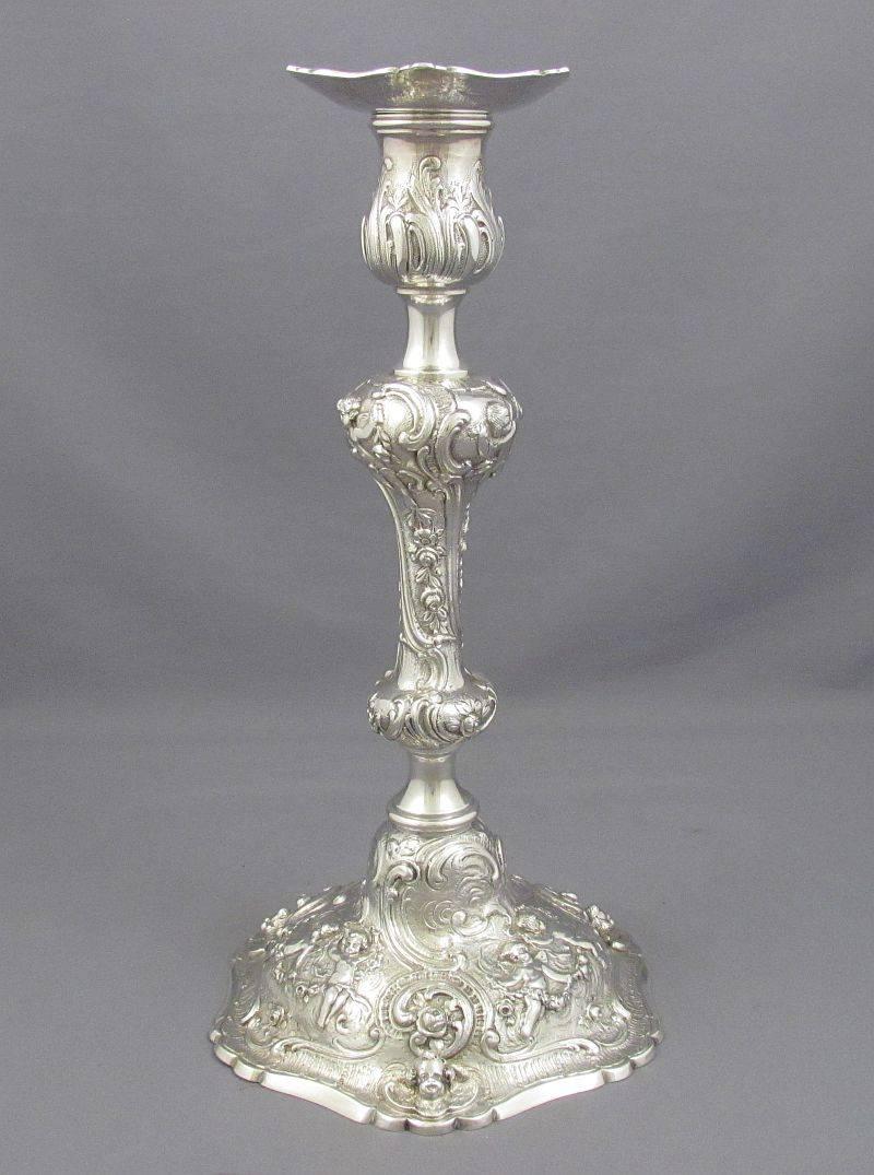 A pair of German sterling silver candlesticks, Hanau, circa 1900, with retail mark for Marshall Field & Co. of Chicago. With beautiful embossed and applied Rococo decoration of flowers, foliage, scrolls and cherubs. Measures: 10.75"