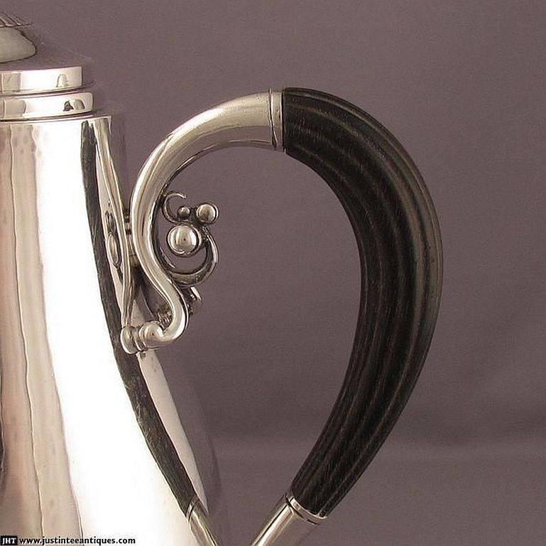 A sterling silver coffee pot by Georg Jensen, Copenhagen 1933-1944, in cosmos pattern, design number 45A. Engraved on the underside with a crest, monogram and presentation date. Measures: 9.5" (24.2cm) high, 19.6 ozt (609g).