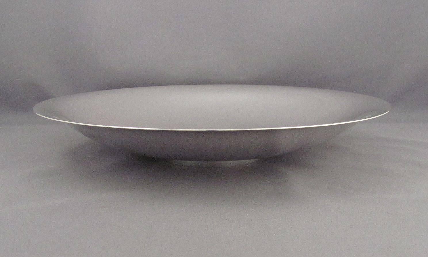 A large sterling silver bowl by Georg Jensen, Copenhagen post 1945, design #620d. Designed by Harald Nielsen, shallow circular form with everted rim on ring foot, subtle hammered finish. Measures: 11 5/8" (29.5cm) diameter, 1 7/8" (5cm)