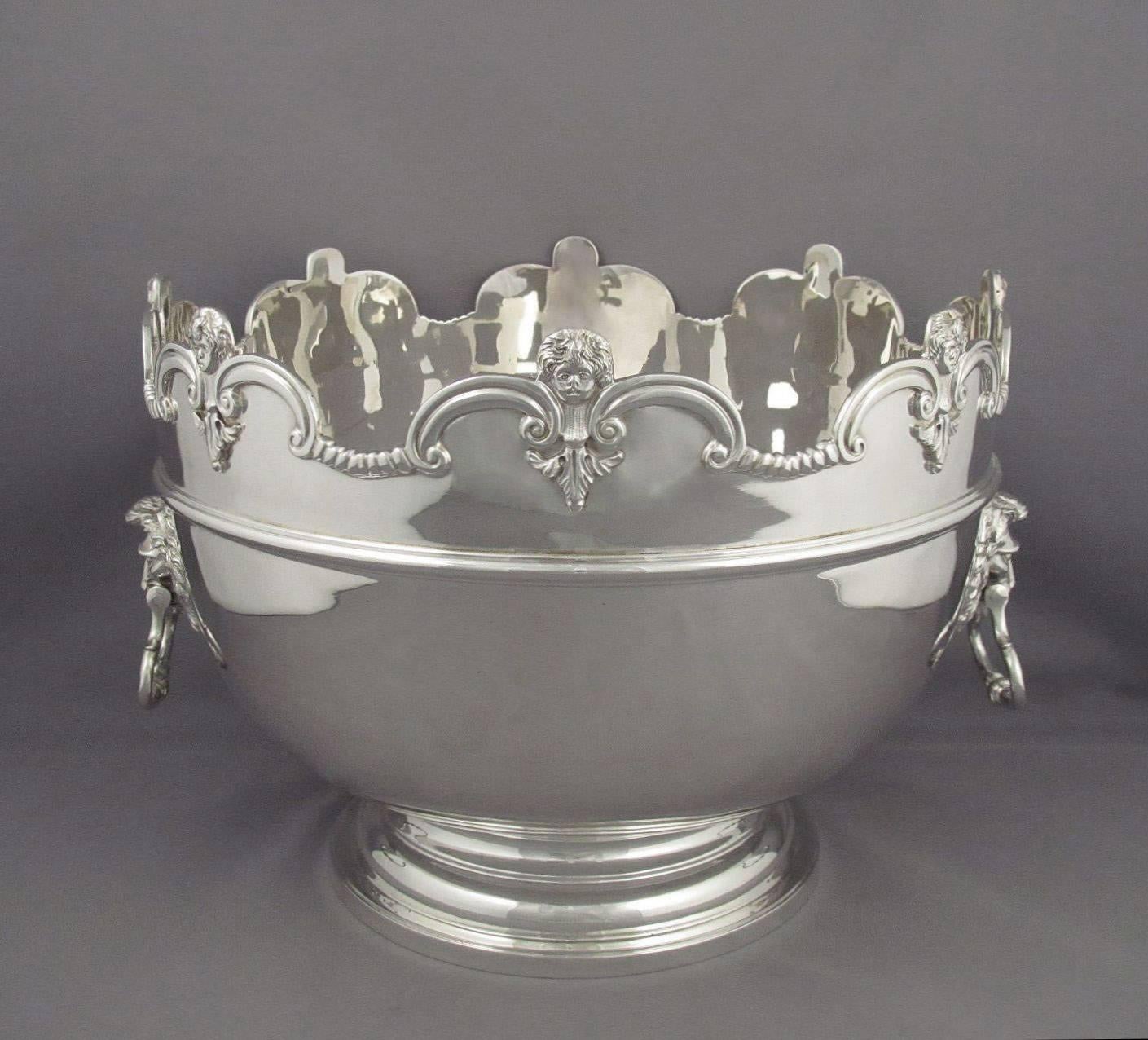 A rare set of three sterling English silver Monteith bowls by Crichton Brothers, hallmarked London 1912. A stunning suite of silver Monteiths consisting of a punch bowl and two rose bowls, each circular on spreading foot with notched rim with mask