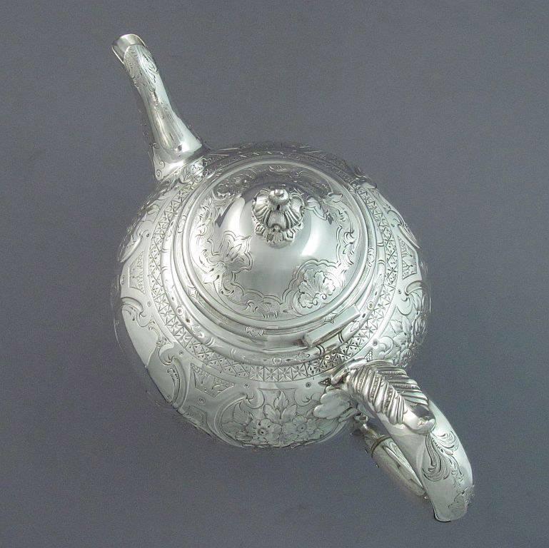 A Victorian sterling silver teapot by Martin Hall & Co., Sheffield, 1856. Antique silver teapot, urn shaped on pedestal foot with scroll handle and spout, the body flat chased with flowers, scrolls and foliage. Measures: 8.75