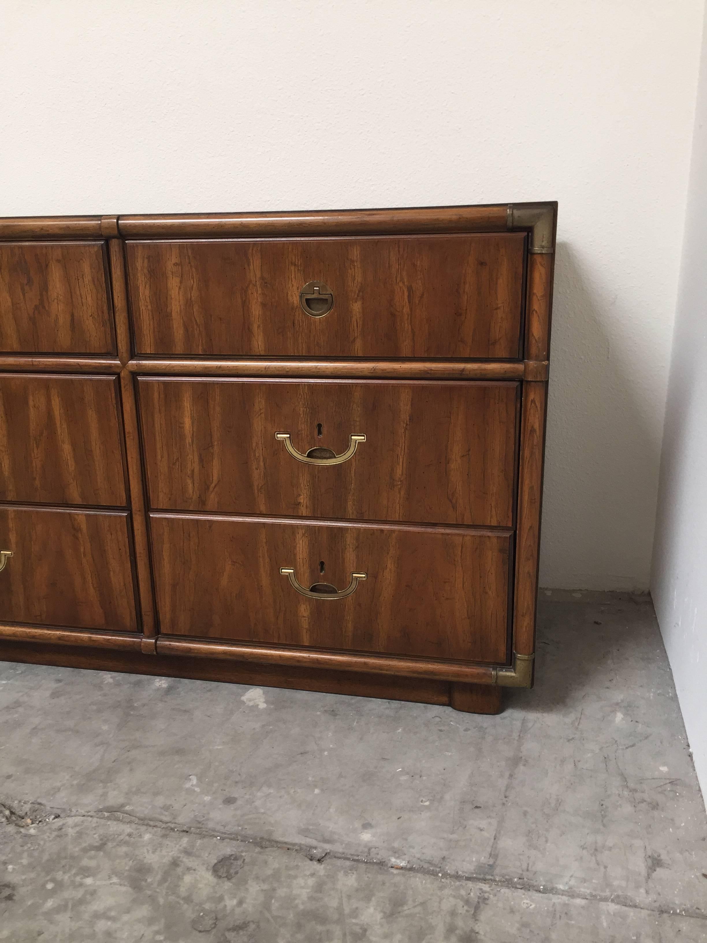 Walnut Campaign style dresser by Drexel. This 1970s piece boasts all original brass hardware with nine drawers. Outstanding vintage condition.