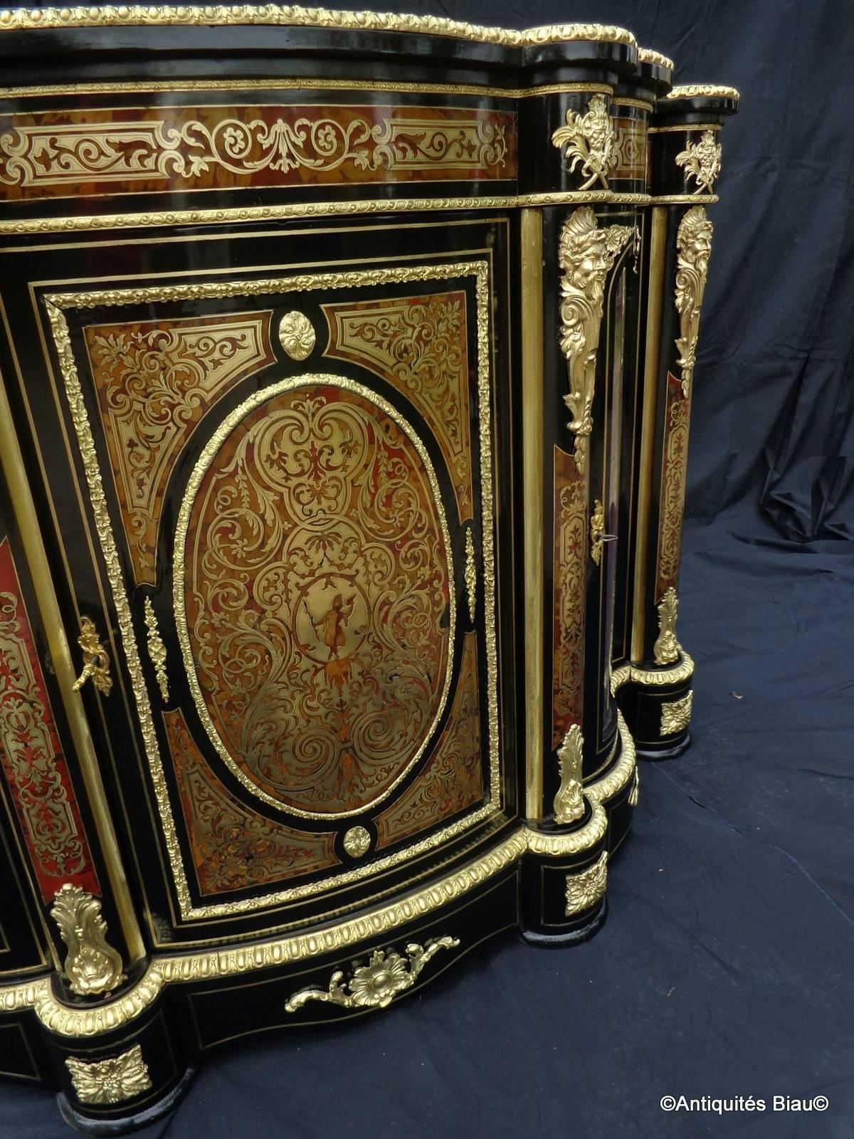French credenza with three doors in Boulle marquetry - period Napoléon III.
A very impressive french credenza in Boulle marquetry, 
opening on three doors.
Beautiful ormolu caryatids.
Eventful glass doors, with old panes (of origins).
Velvet