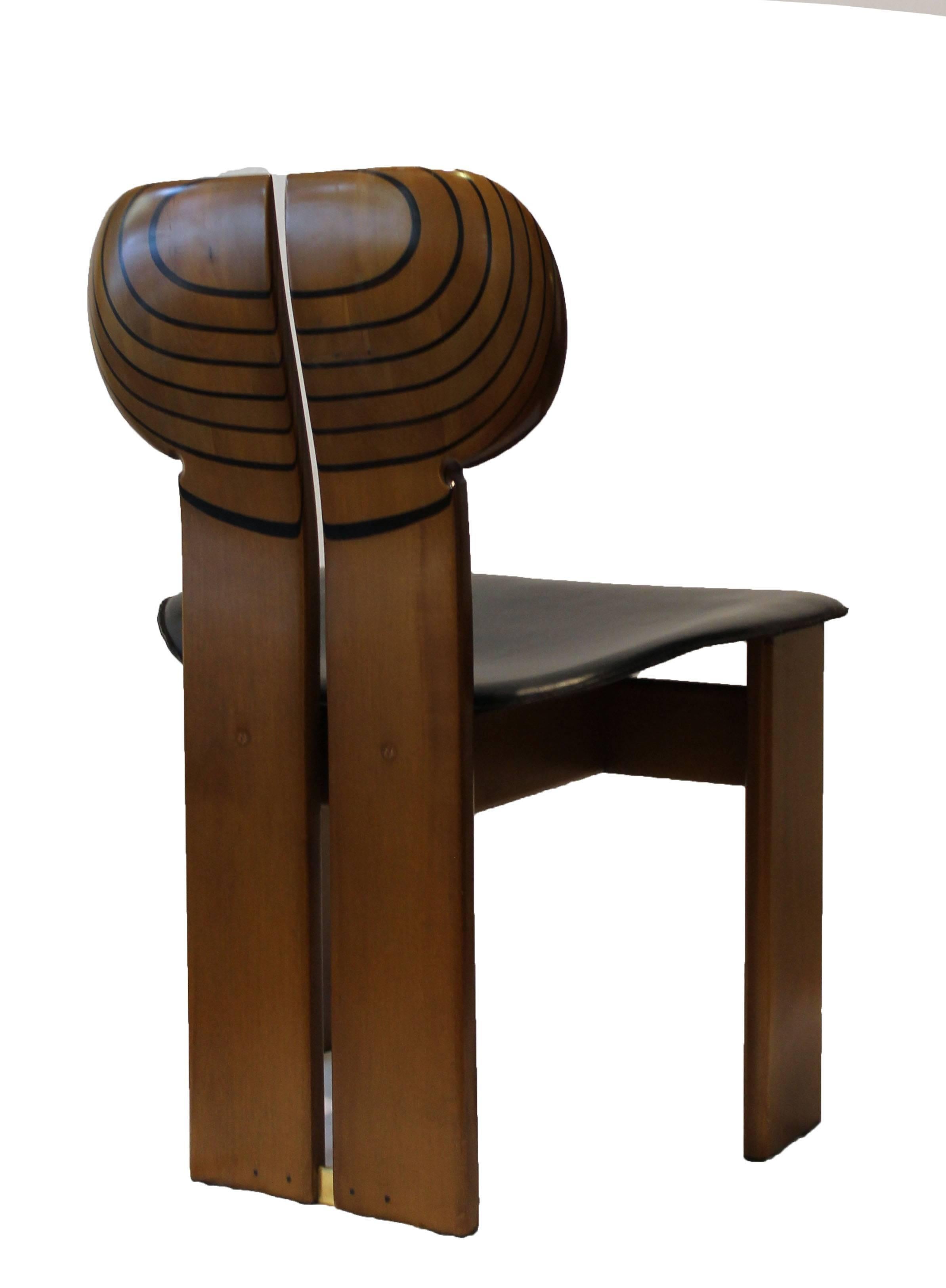 Five Africa chairs, from Artona series, designed by Afra e Tobia Scarpa for Maxalto (B&B Italia). Walnut and ebony wood, leather covered seat and brass details. Africa table available on request.

The Africa chair from the Artona series was