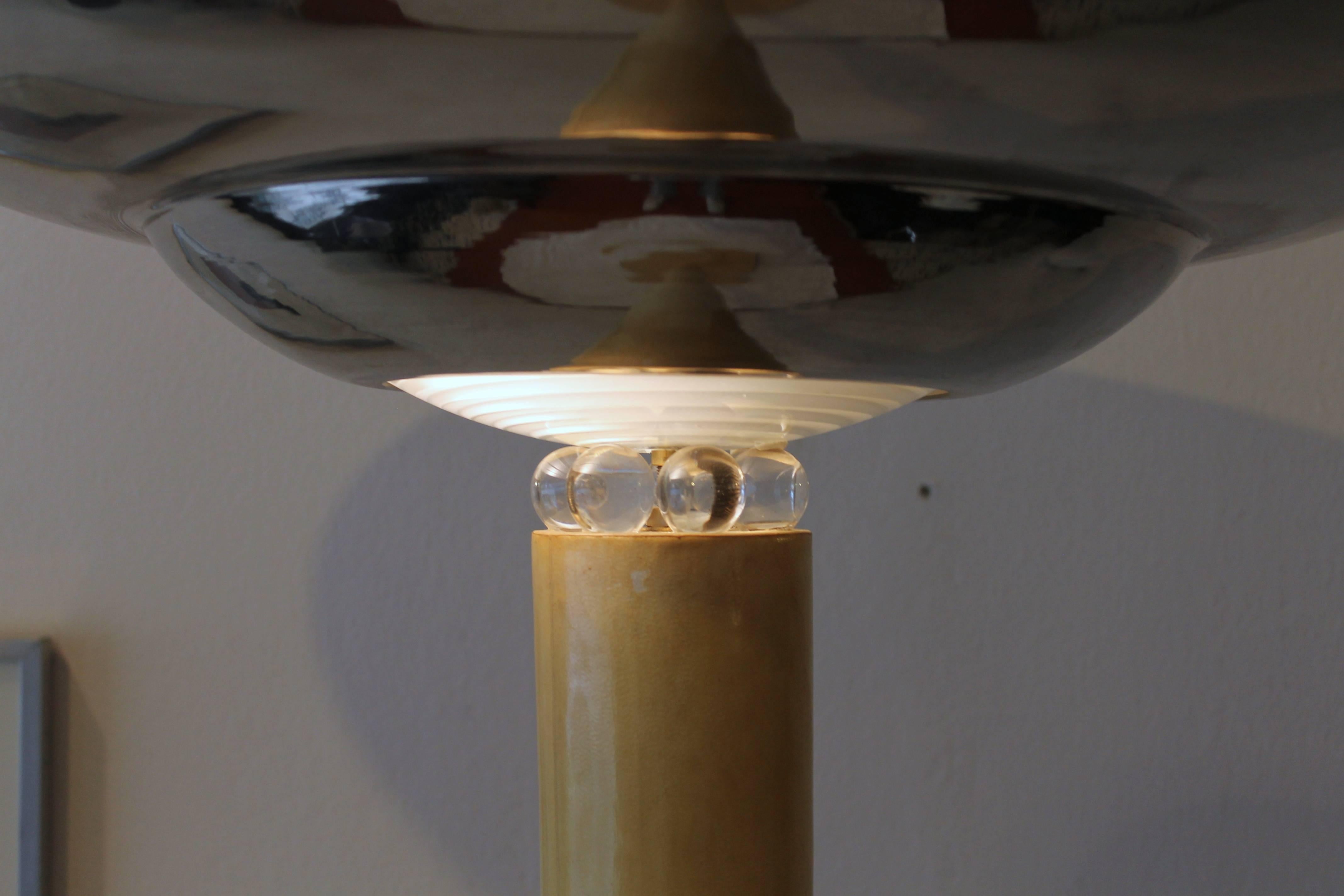 Art Deco floor lamp, dated circa 1935.
Lambskin upholstered base and shaft. Big chrome metal lampshade with small glass spheres on the base, which reflect the light all around.
 