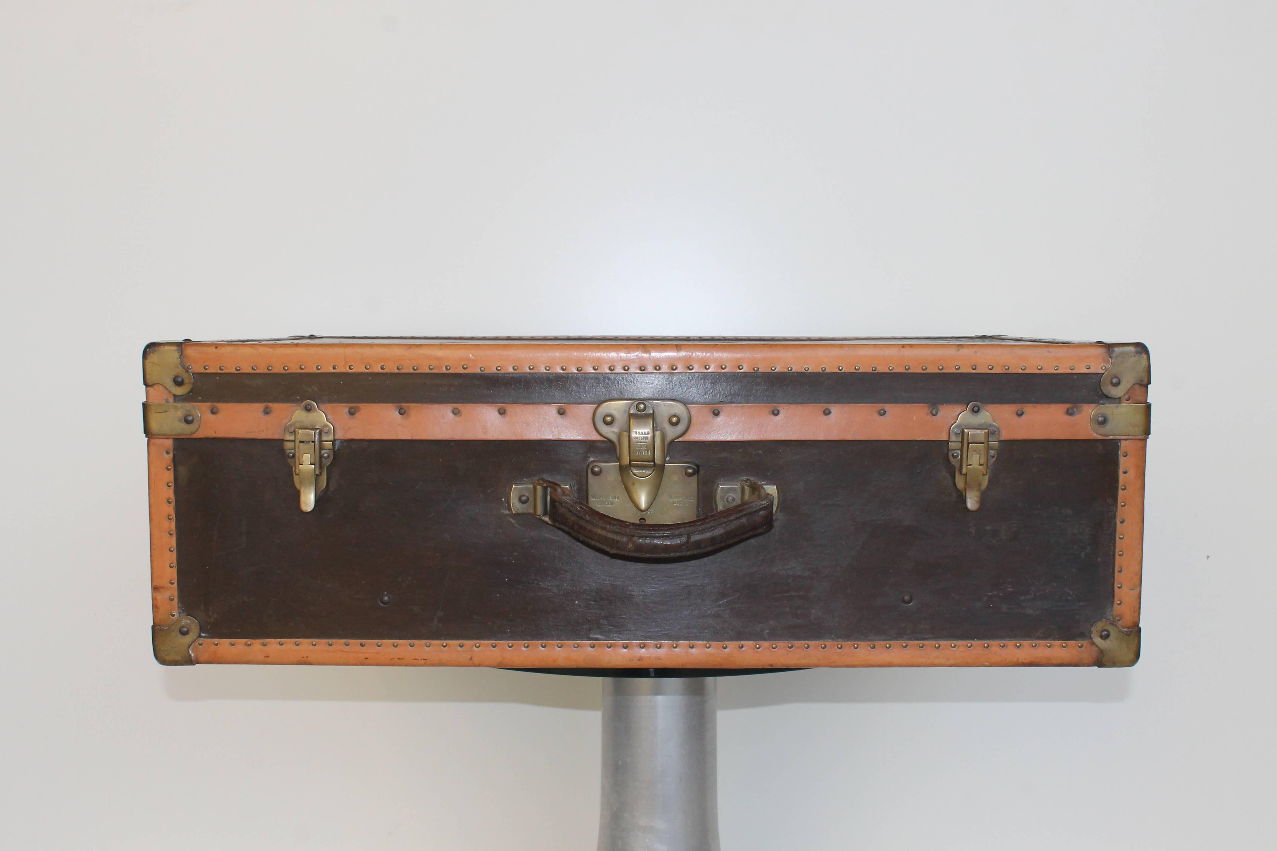 Suitcase by Louis Vuitton, dated 1910 circa. Engraved latch, brown and camel leather.