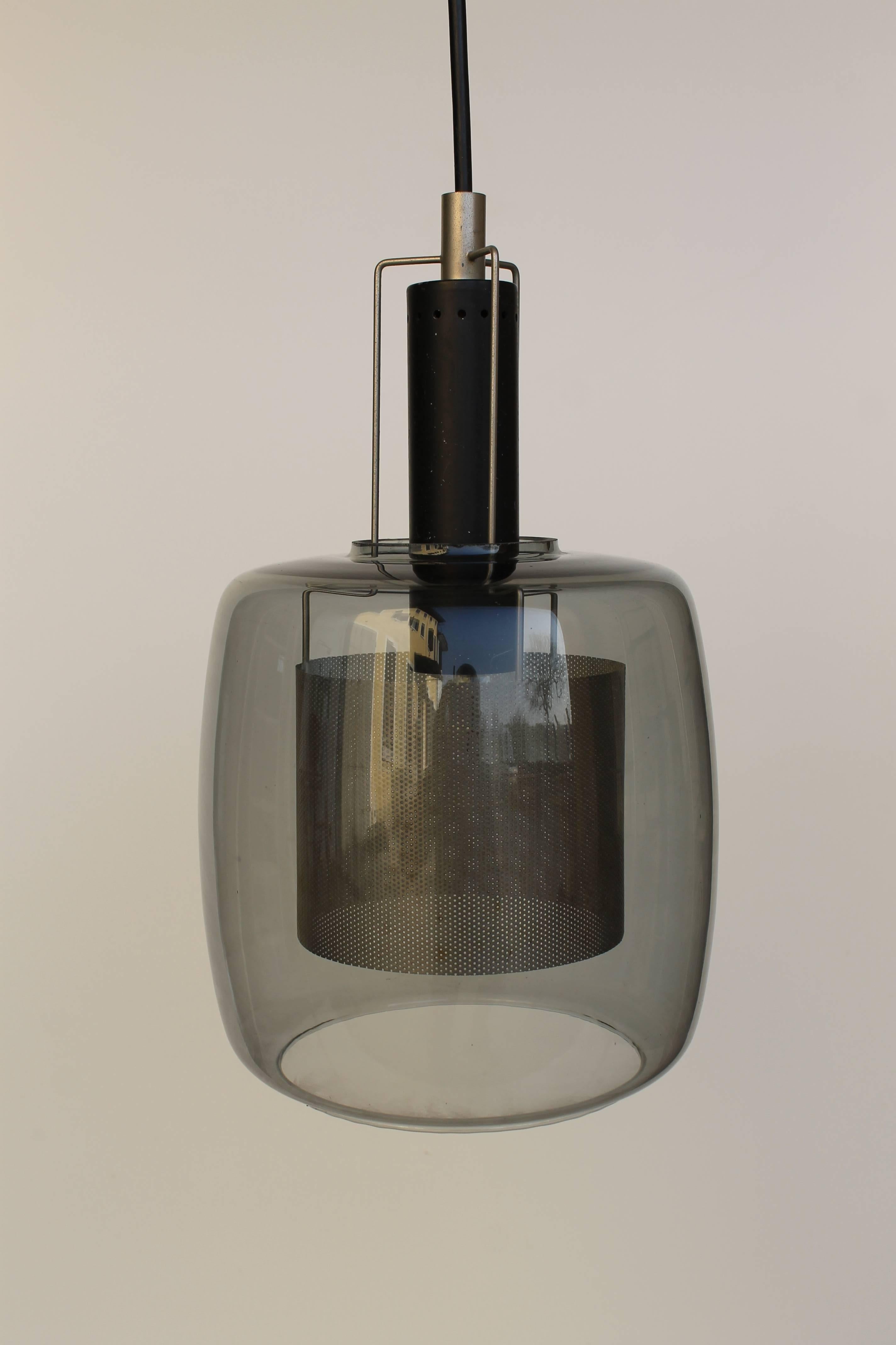 Vintage lamp with a pierced surface and glass bell, circa 1960.