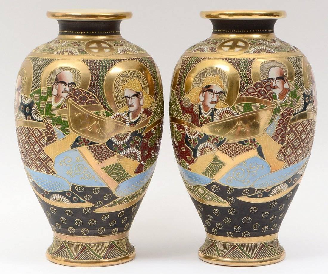 Beautiful and charming pair of Japanese Satsuma vases from early 20th century. These are hand-painted ceramic with relief decorations of raised enamel. Charming scene with both male and female immortal subjects. Of a size and scale to work in many