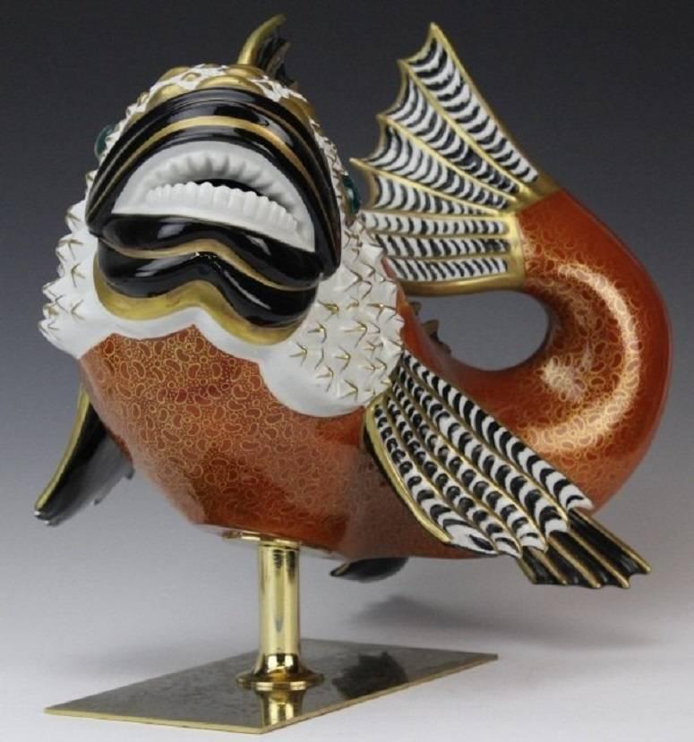 A masterwork of Italian craftsmanship by the Mangani family in partnership with the Oggetti company. This fish has a gilt, painted and enameled porcelain body, raised on a brass base. These fish and bird sculptures by the Oggetti company were made