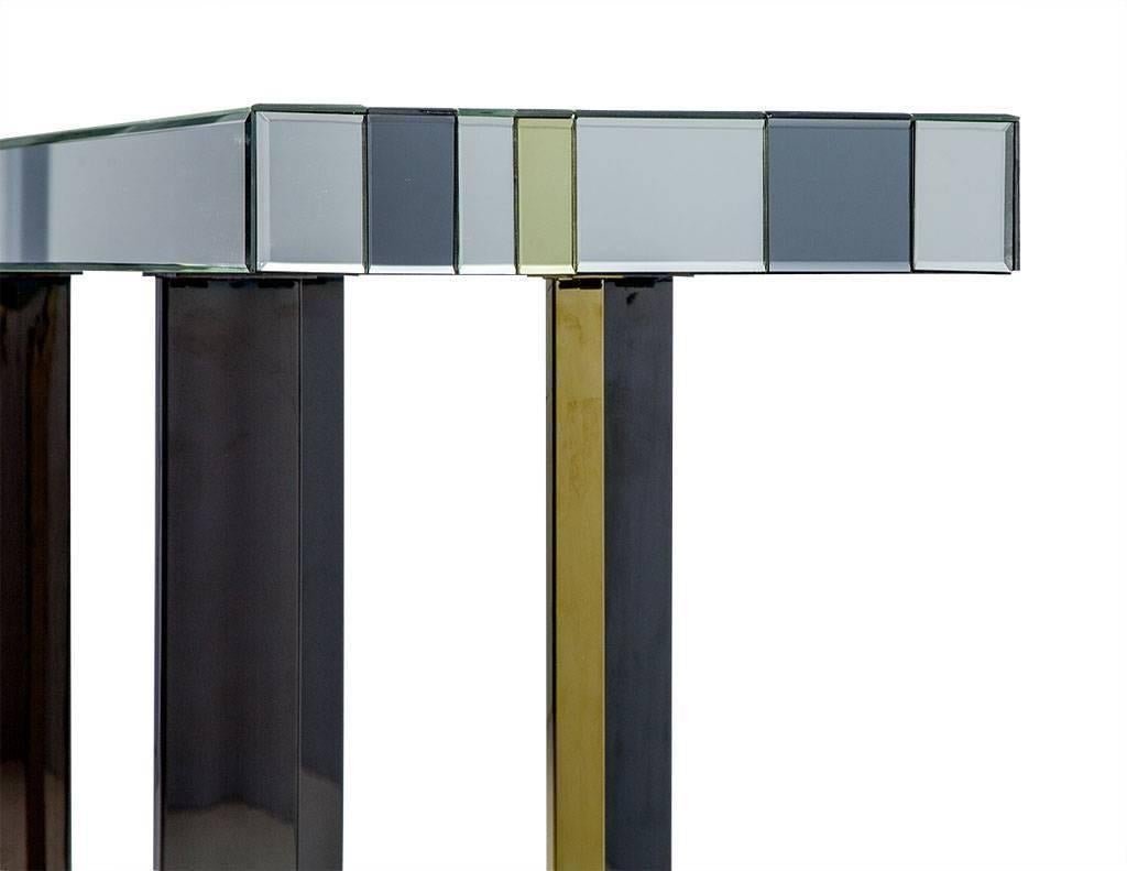Thick, mirror-topped console table with dark platinum, gold and regular mirror stripes. Dark platinum and gold finished stainless steel legs of different thicknesses add to the pieces appeal. Reminiscent of the styles of Karl Springer or Romeo Rega.