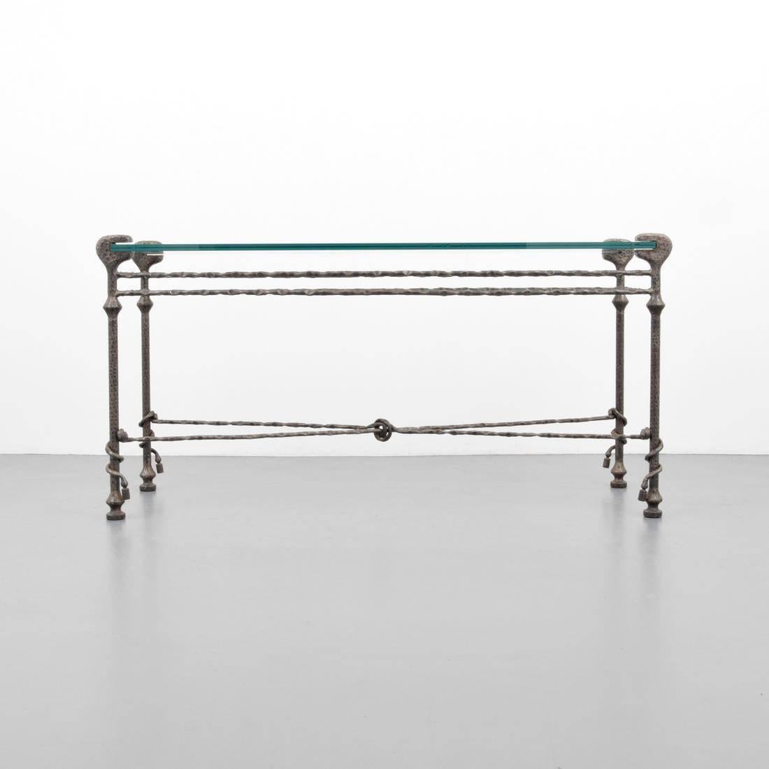This substantial hammered iron and glass console table is created in the manner of Diego Giacometti. This piece hails from the mid-20th century (circa 1960s), but works equally as well in today's interiors. We find there to be both a rustic quality
