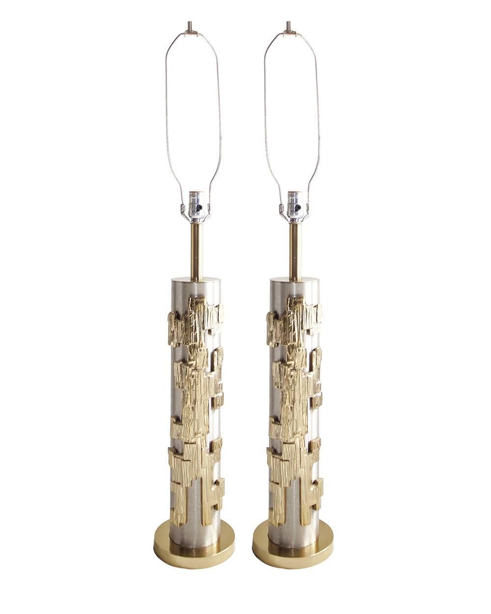 Pair of classic Mid-Century lamps by the Laurel Company in the Brutalist style. Brushed silver metal columns with substantial applied gold-tone bronze elements. Dimensions: H 42 inches x  W 6.25 inches: D 6.25 inches. Newly rewired with clear cord