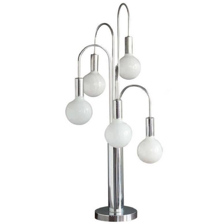 This five-arm table lamp has a very 1970s design rendered entirely in chrome. Five curved branches radiate from the central cylinder in a helix and each ends in an opaque white globe bulb.