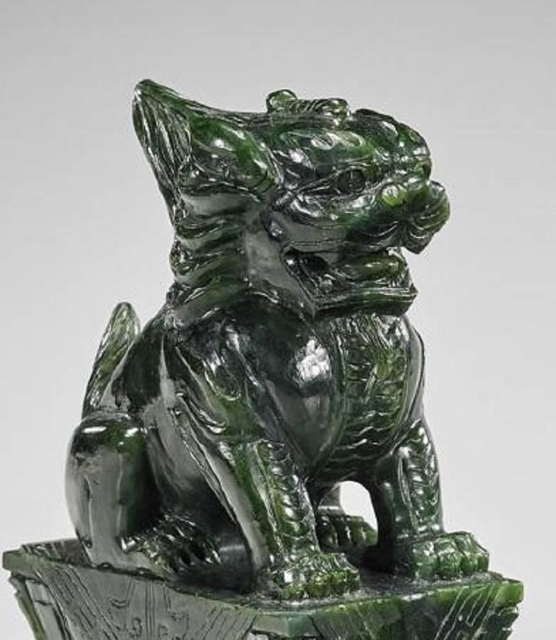 Pair of Chinese carved spinach jade lions; each seated upon a rectangular double lotus pedestal; measures: H 7 3/4