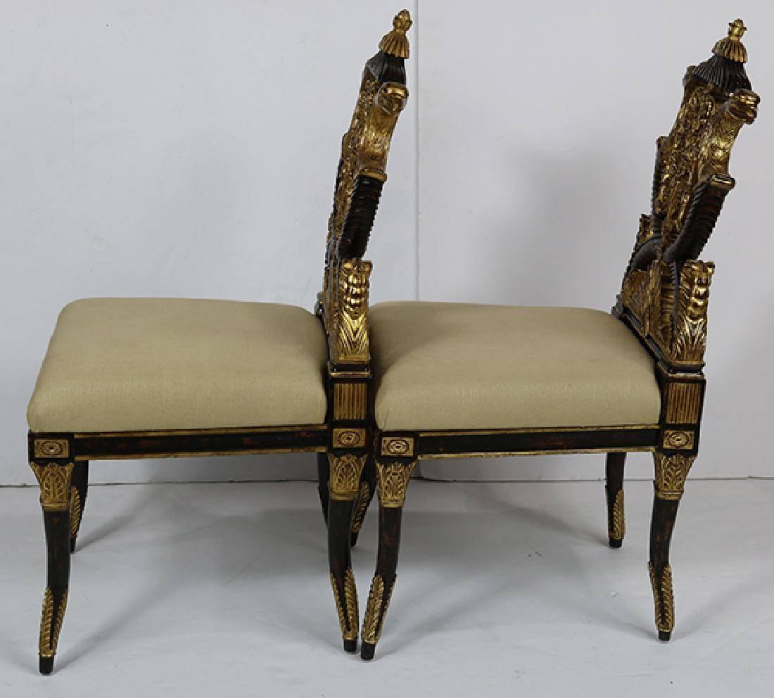 Pair of highly decorative French Empire style hall chairs, each having a partial gilt and pierced back, flanked with eagles, centering scroll and acanthus accents, above the cream upholstered seat and rising on ebonized and partial gilt tapered