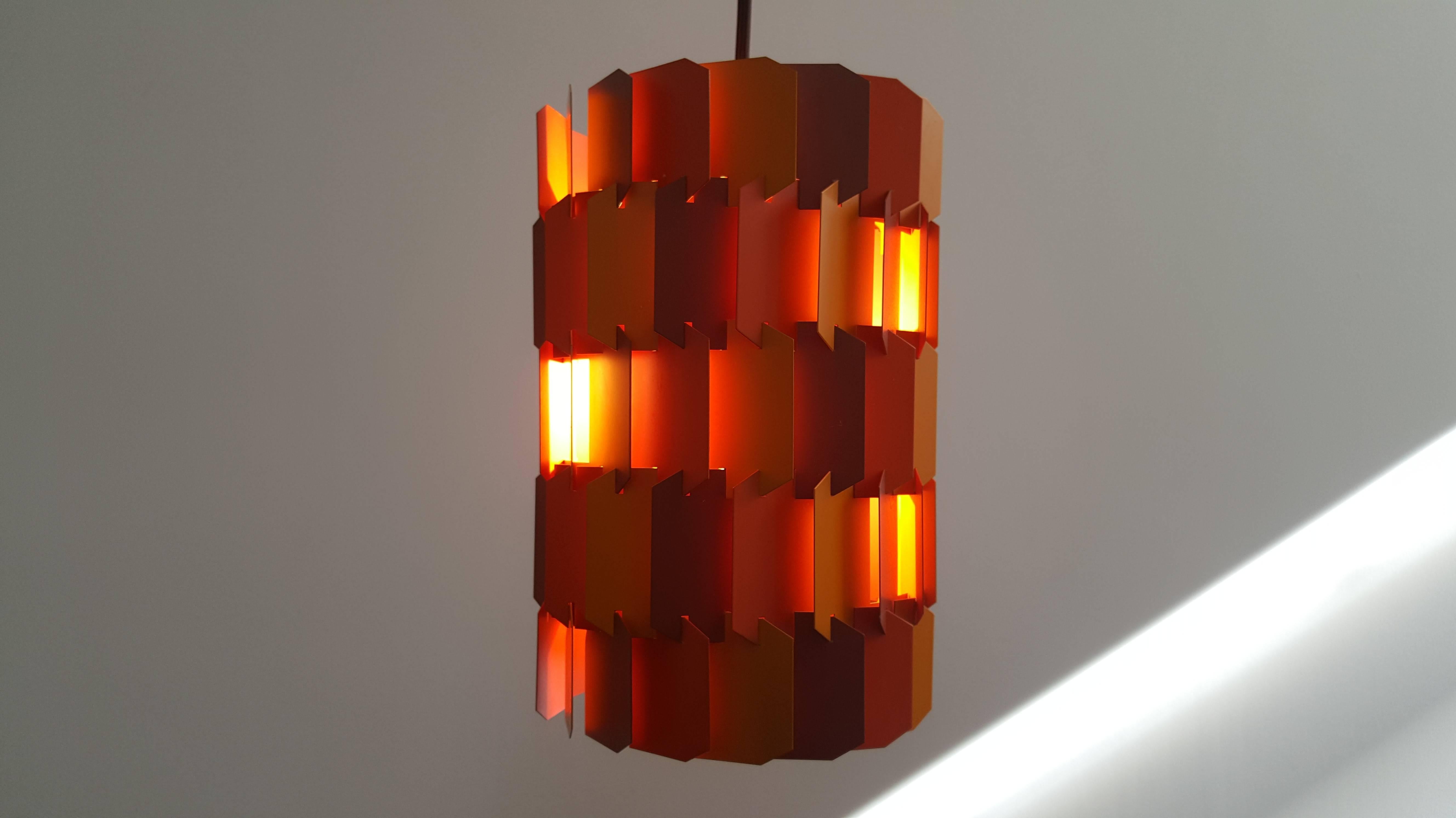 Louis Weisdorf 'Facet' pendant, designed 1970, produced by Lyfa.

The Facet-Pop is constructed from 18 castellated metal strips, identical in shape but in three different tones of color, woven together to form a cylinder. Light emerges through