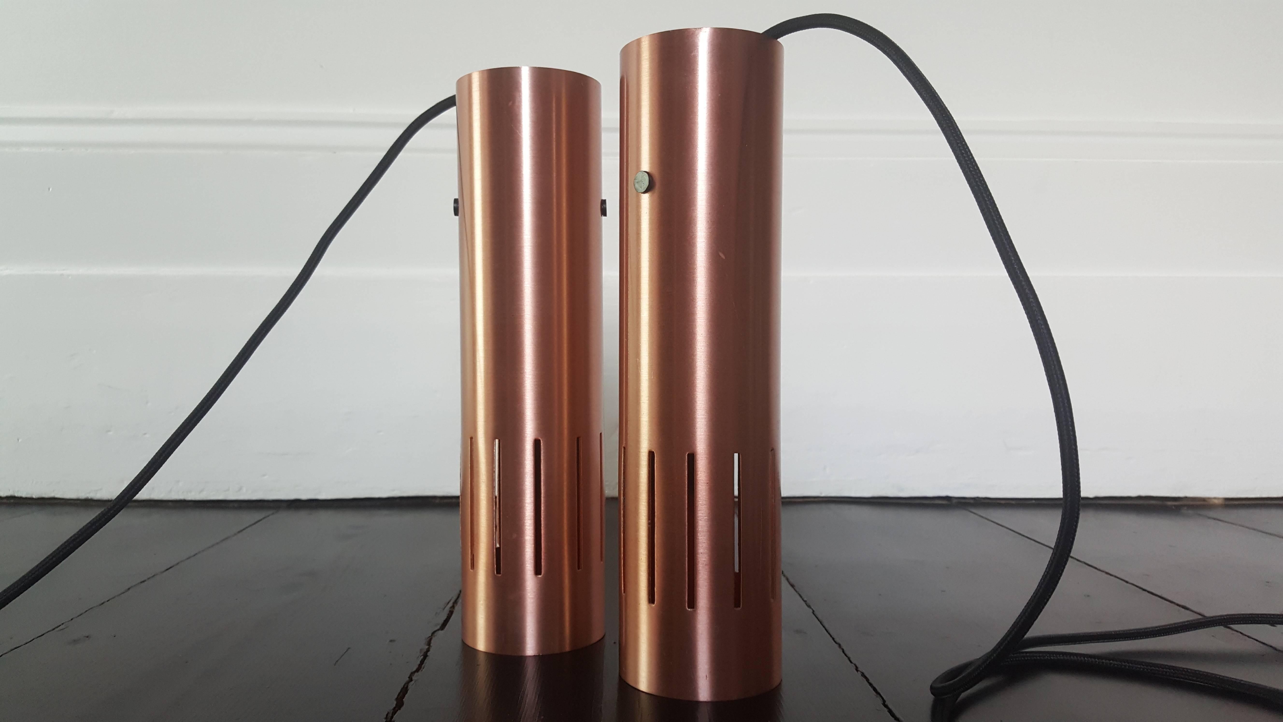 A pair of copper Jo Hammerborg Trombone pendant lights, manufactured by Fog & Mørup in Denmark during the 1960s. Constructed of brass and aluminium.

The pieces have been UK pat safety tested and passed and are provided with minimal black ceiling