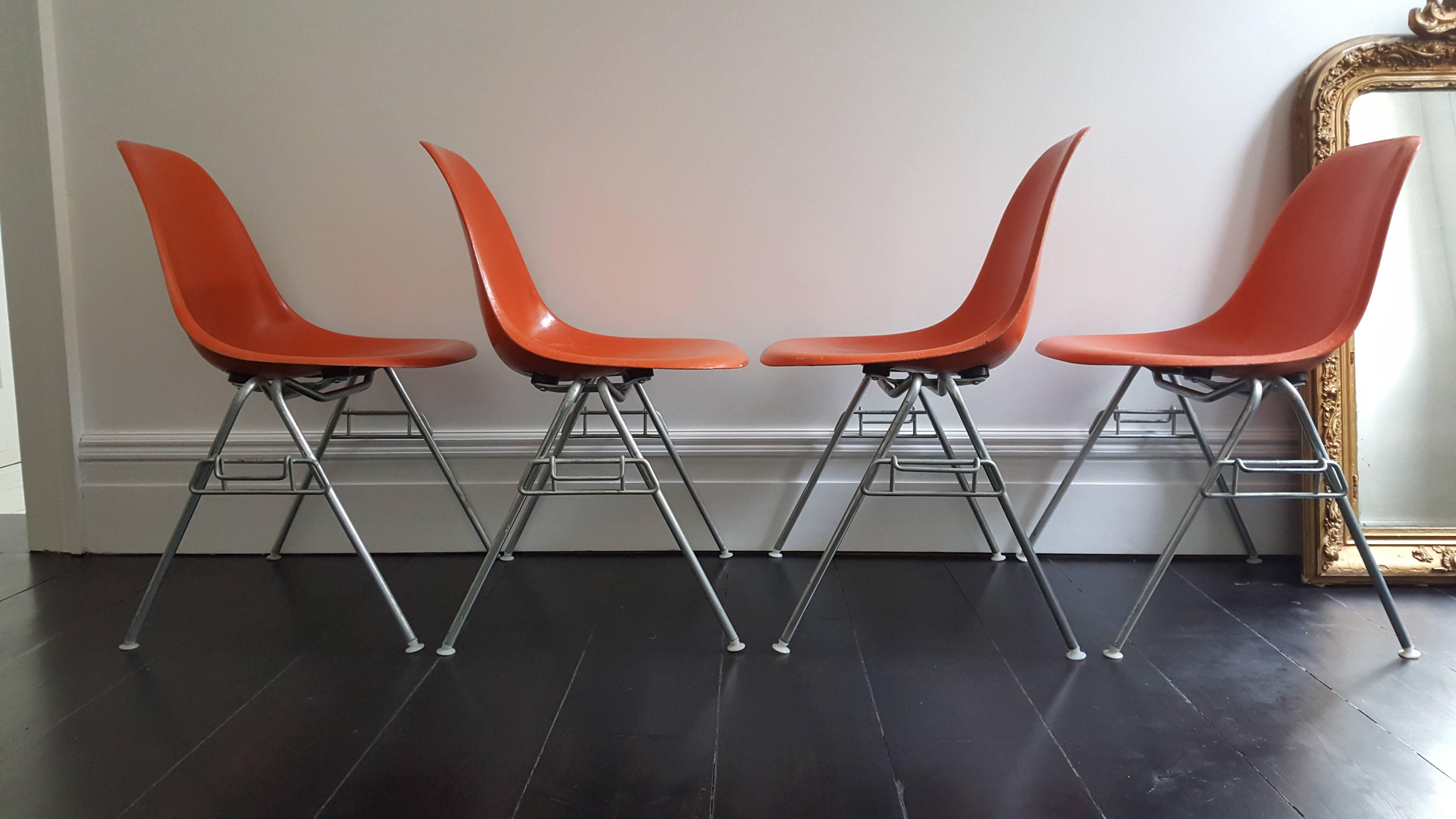 Classic icons, a set of four vibrant orange fiberglass Charles and Ray Eames designed Herman Miller DSS chairs on matt steel stacking bases.

Great provenance, these came out of Wayne State College Nebraska with labels reflecting this - great