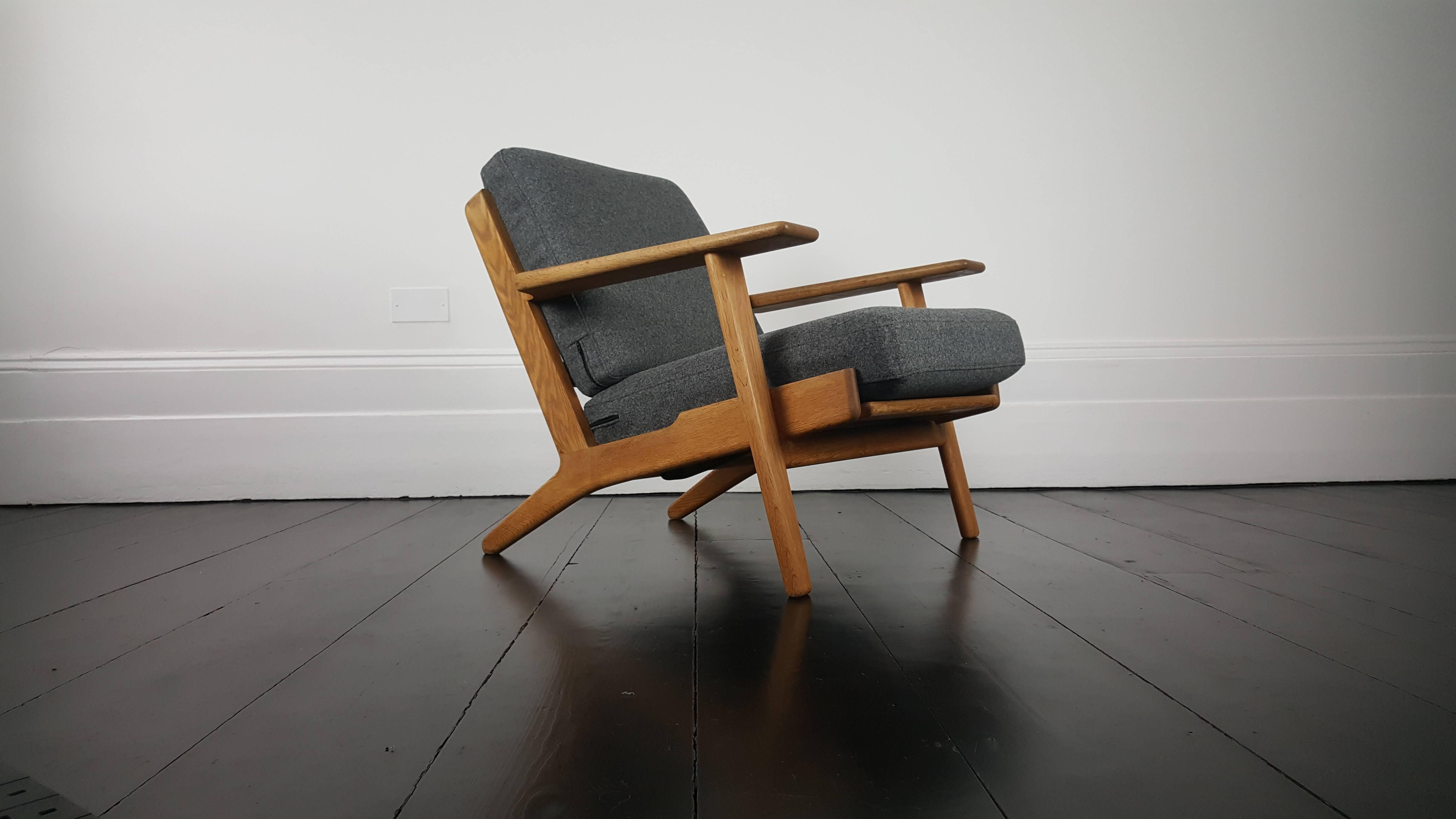 An original iconic Hans J. Wegner GE290 Oak framed armchair Designed in the late 1950s and produced by GETAMA, Denmark, with makers marks displayed. 

The piece features new mid grey Wool upholstery and is in very nice condition and has a