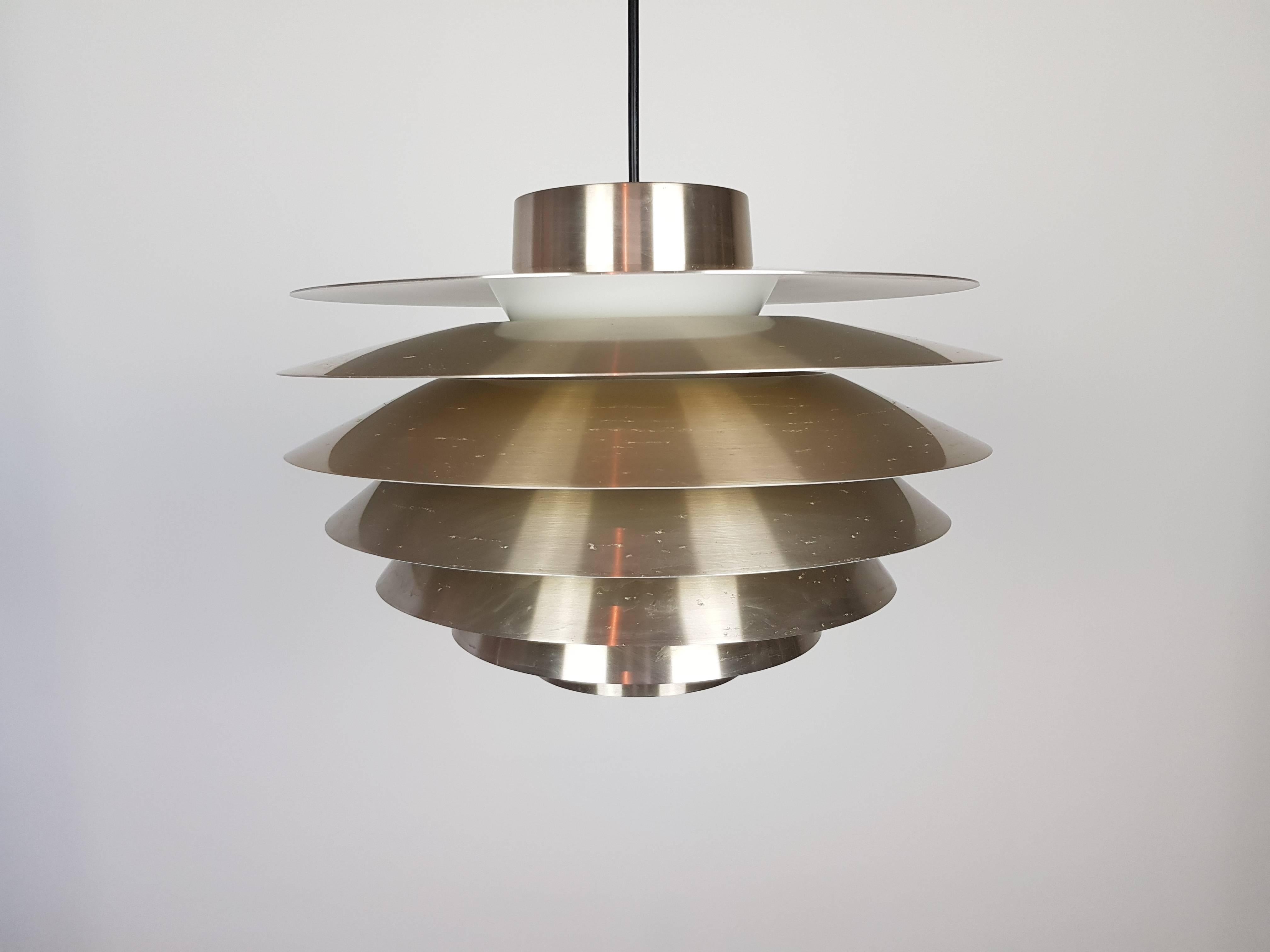 A vintage brassed Svend Middelboe Verona pendant light produced by Nordisk Solar, 1970s

Constructed from tiers of aluminium emitting a warm subtle glow when lit.

Fully working, rewired, safety tested and passed, supplied with a contemporary