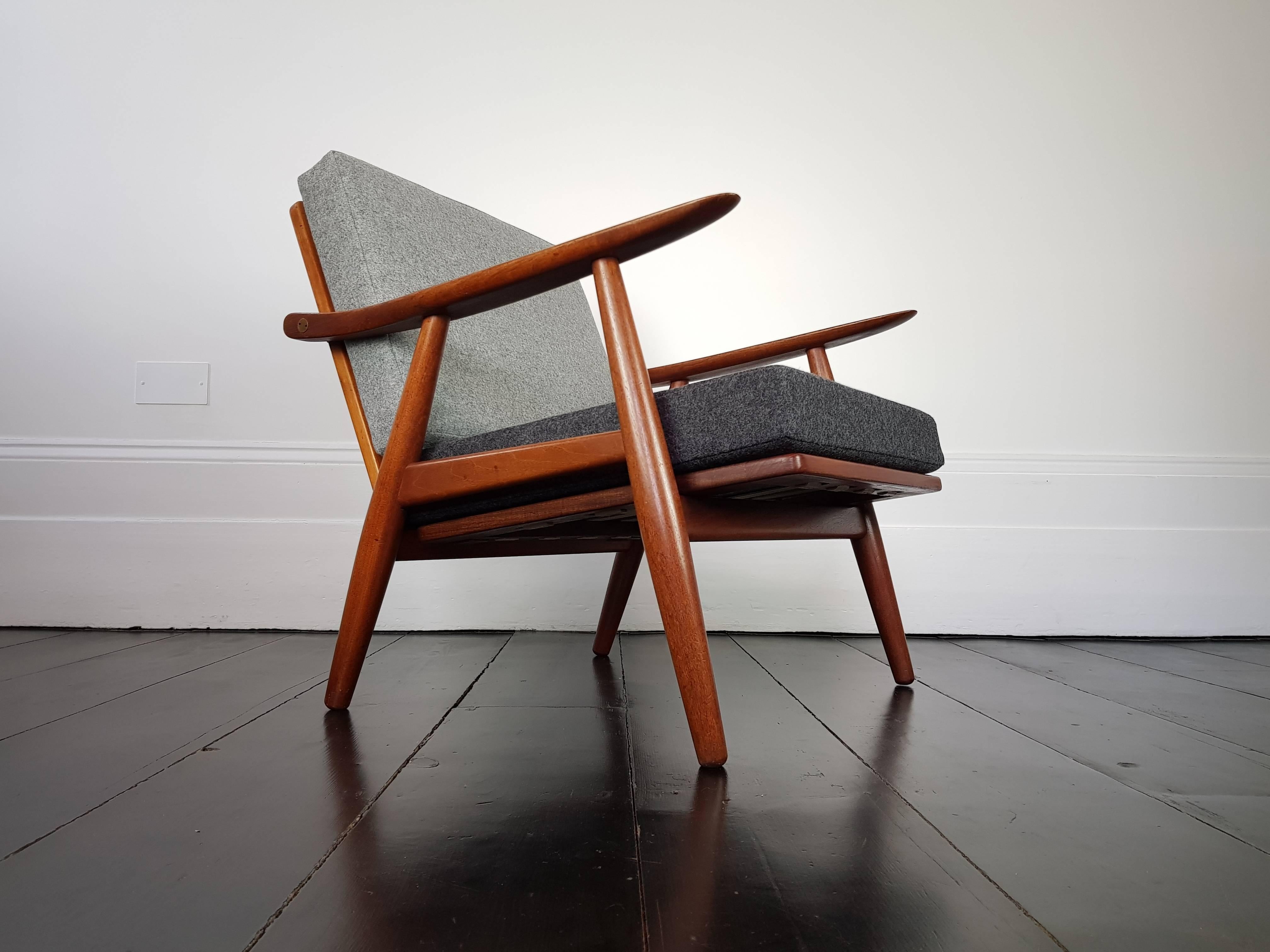 A Hans J. Wegner GE-270 lounge chair for GETAMA, Denmark, 1956.
 
Hans J. Wegner GE-270 lounge chair, 1956 produced by GETAMA Gedsted, Denmark. Teak frame with brass fittings. Featuring new two-tone grey fabric both from the Abraham Moon Melton