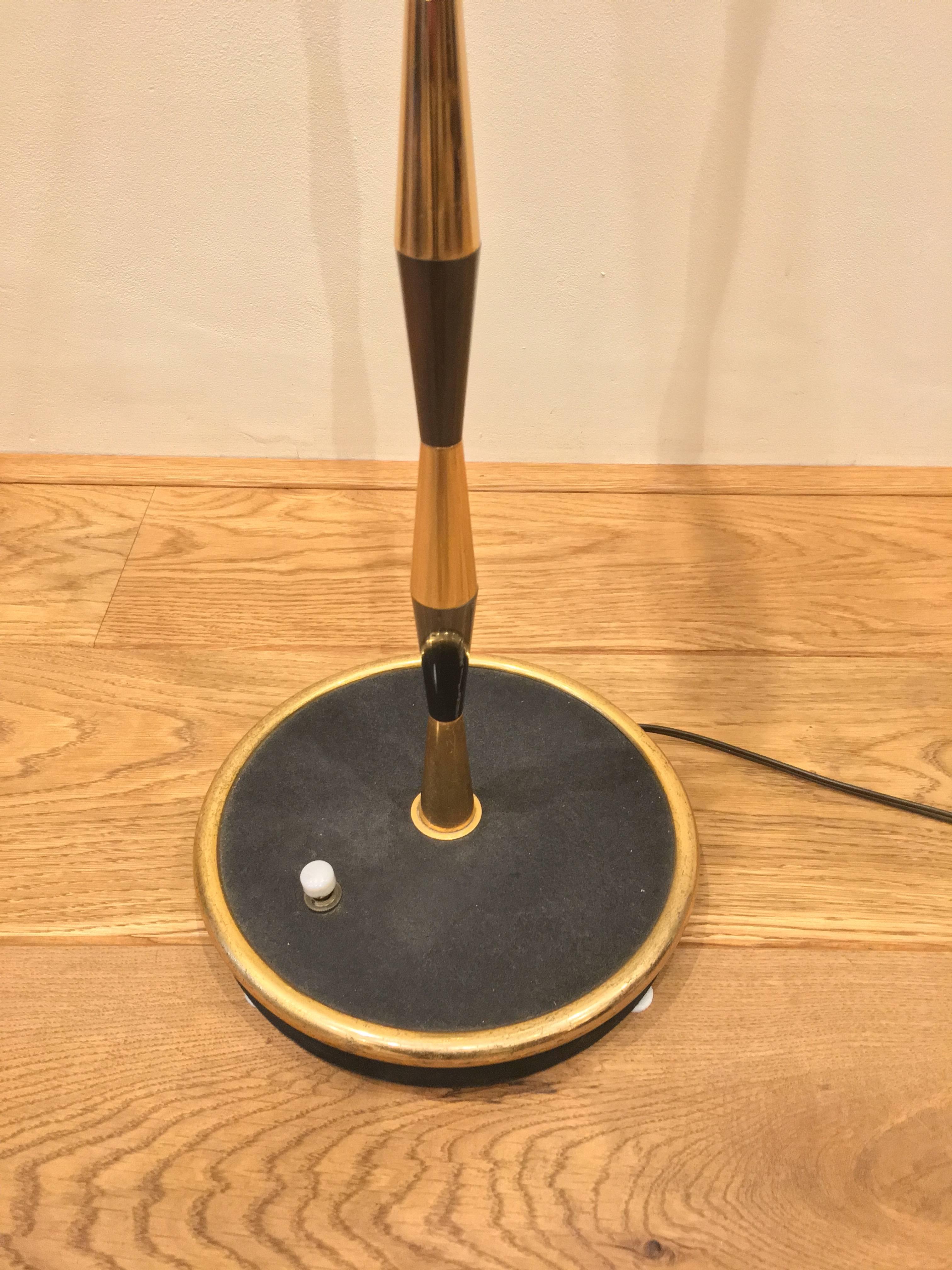 The floor lamp is made of cone shaped brass and canon de fusil metal elements. The foot is black metal circle by a brass ring. The original switch is still in use.
