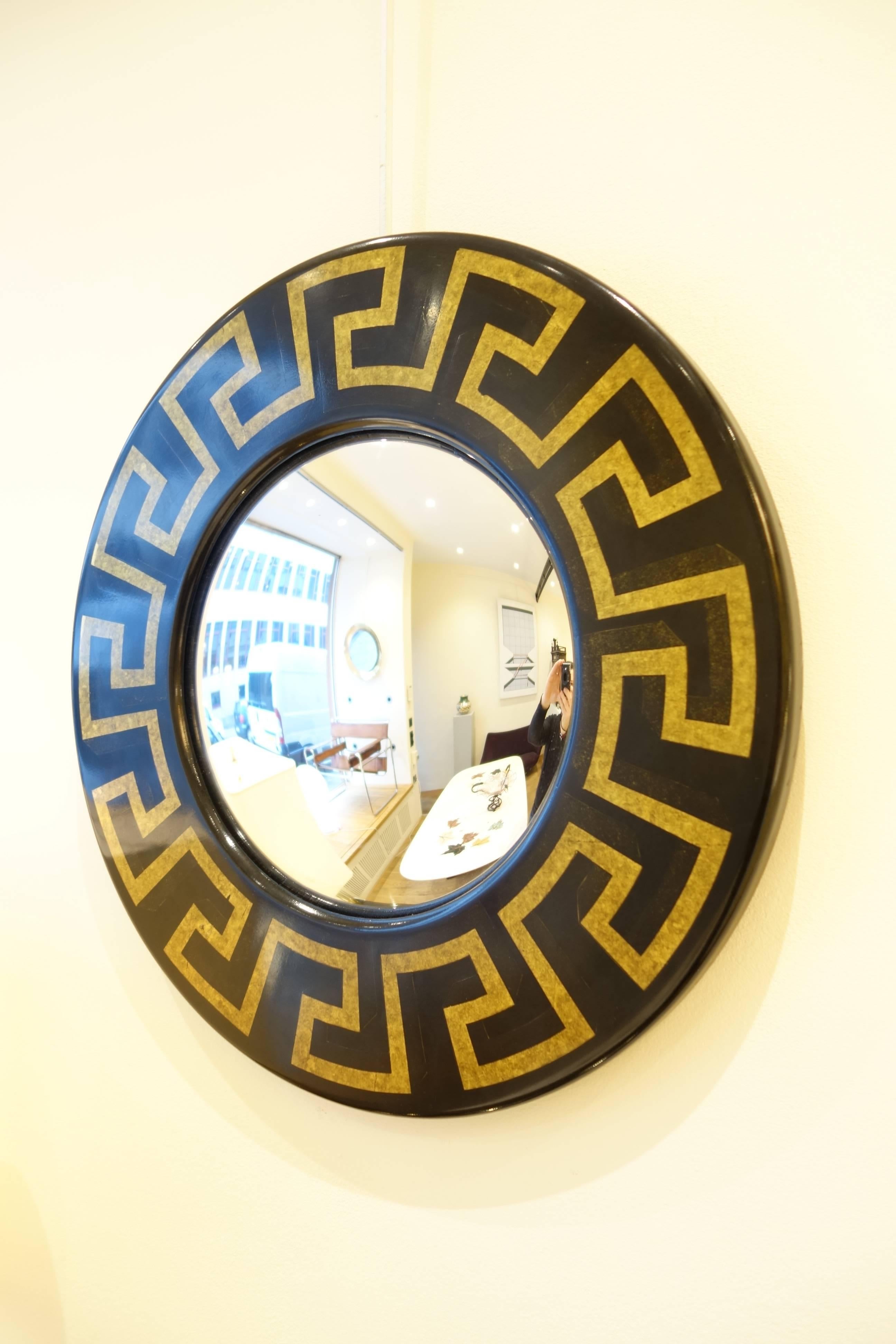 A circular mirror with gilt Greek pattern. The mirror convex shaped. Signed with original sticker.