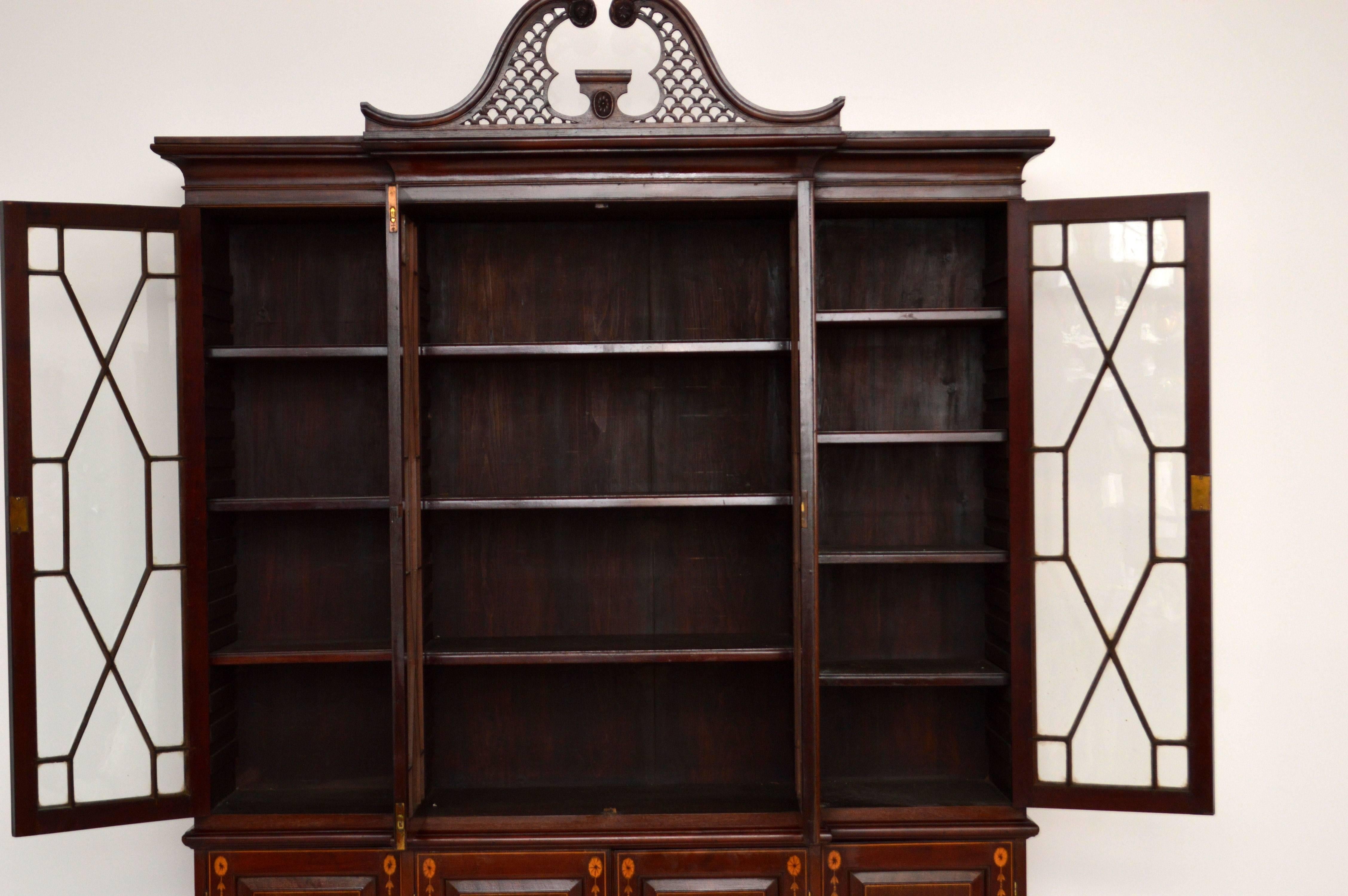 This large antique Edwardian mahogany breakfront bookcase is wonderful quality and has fine satinwood inlays all-over. Please enlarge all the images to appreciate all the fine details. The top pediment can be taken off if it makes the bookcase too