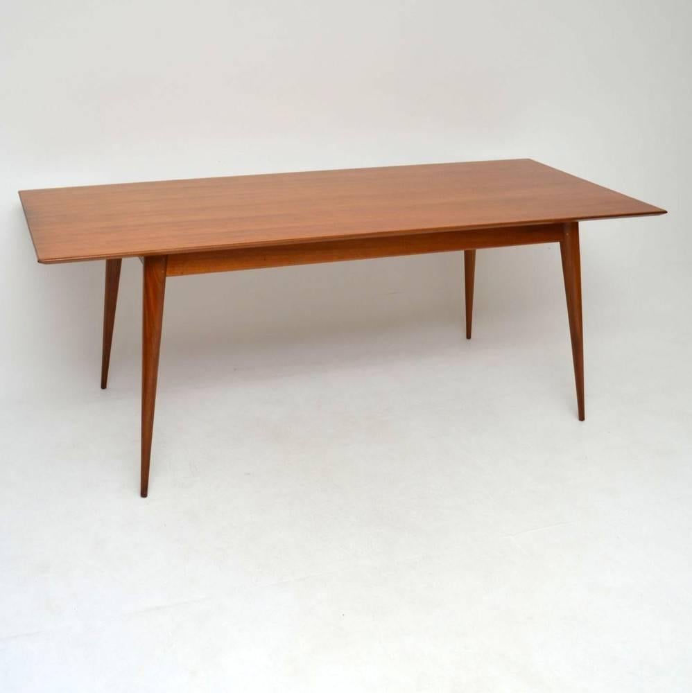 A very impressive Walnut dining table from the 1950s, it's very unusual to find a large and elegant fixed top Mid-Century table of these proportions. We're not sure who designed it but the quality is amazing, it looks like it could possibly be