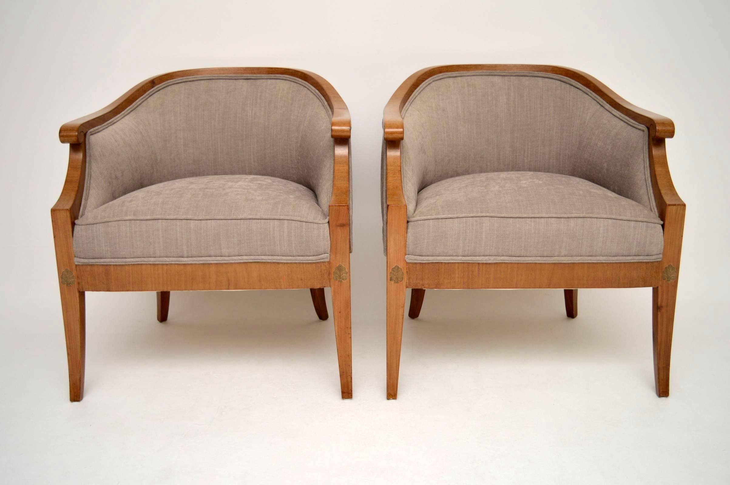 Very smart and elegant pair of antique Swedish armchairs in satin birch, dating from circa 1910 period or possibly earlier. They have tub shaped backs and sabre legs. There are some small inlaid motives on the tops of all the legs, back and front.