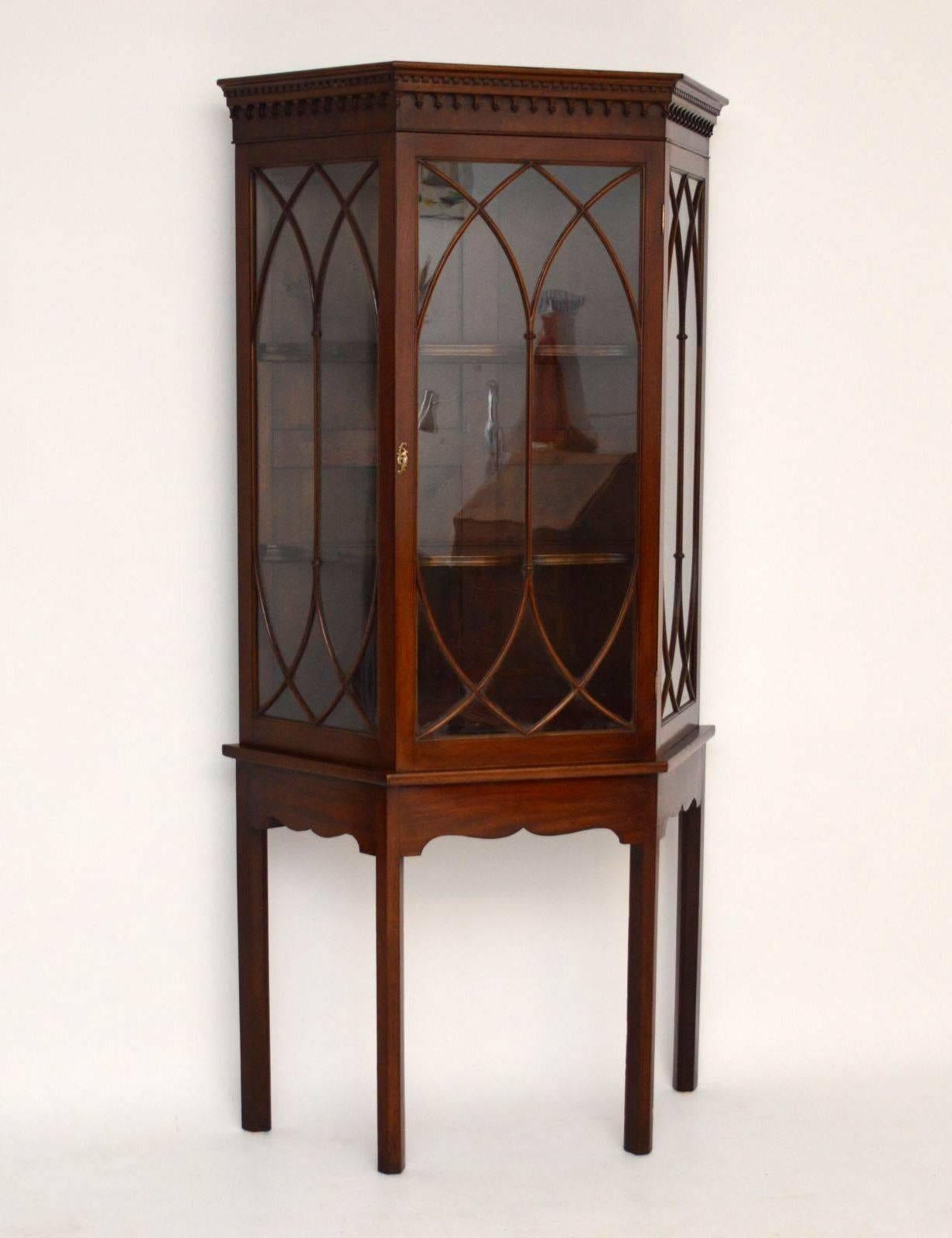 Impressive antique mahogany display cabinet in good original condition, with original colour and patina. The top cornice has a dental frieze with tear drop mouldings below. The astral glazing is of Gothic design and the shelves inside the cabinet