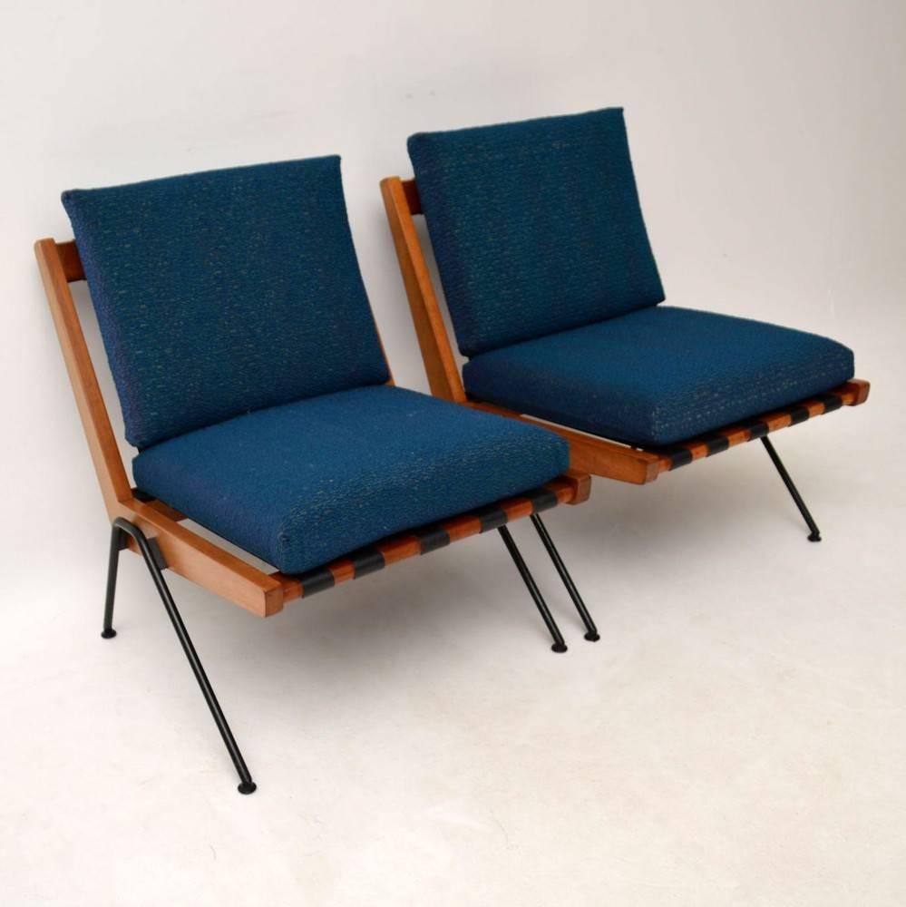 A super stylish and rare pair of Chevron chairs, these were designed by Robin Day, they were made by Hille in the 1950s. The condition is excellent for their age, with just some extremely minor wear here and there. The blue wool cushion covers are