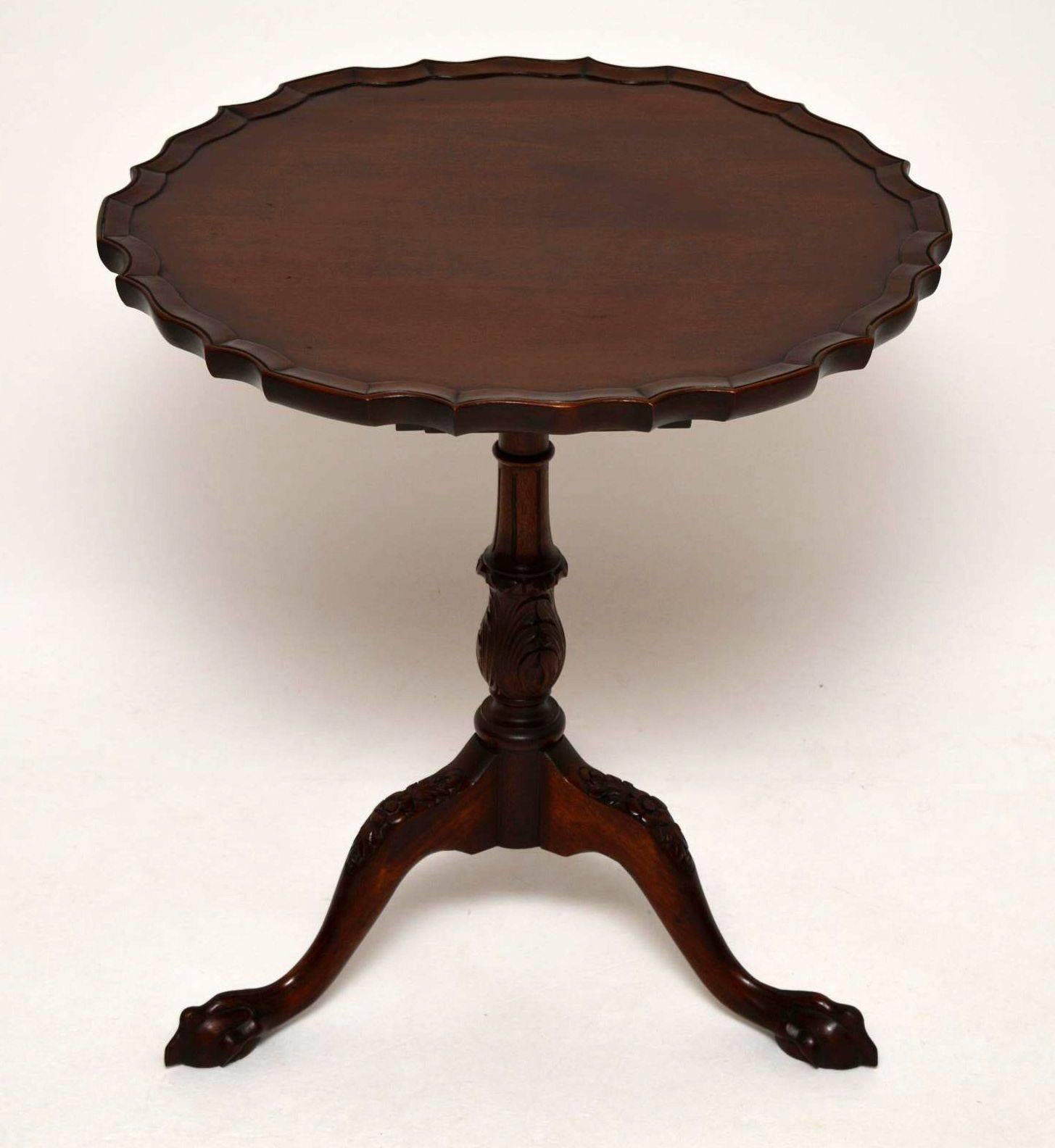 Antique Chippendale style mahogany tilt-top table with a pie crust shaped edge. It has a carved baluster stem, with carved tripod legs and claw and ball feet. This table also sits on a bird cage base which helps it tilt, revolve and come apart. It's