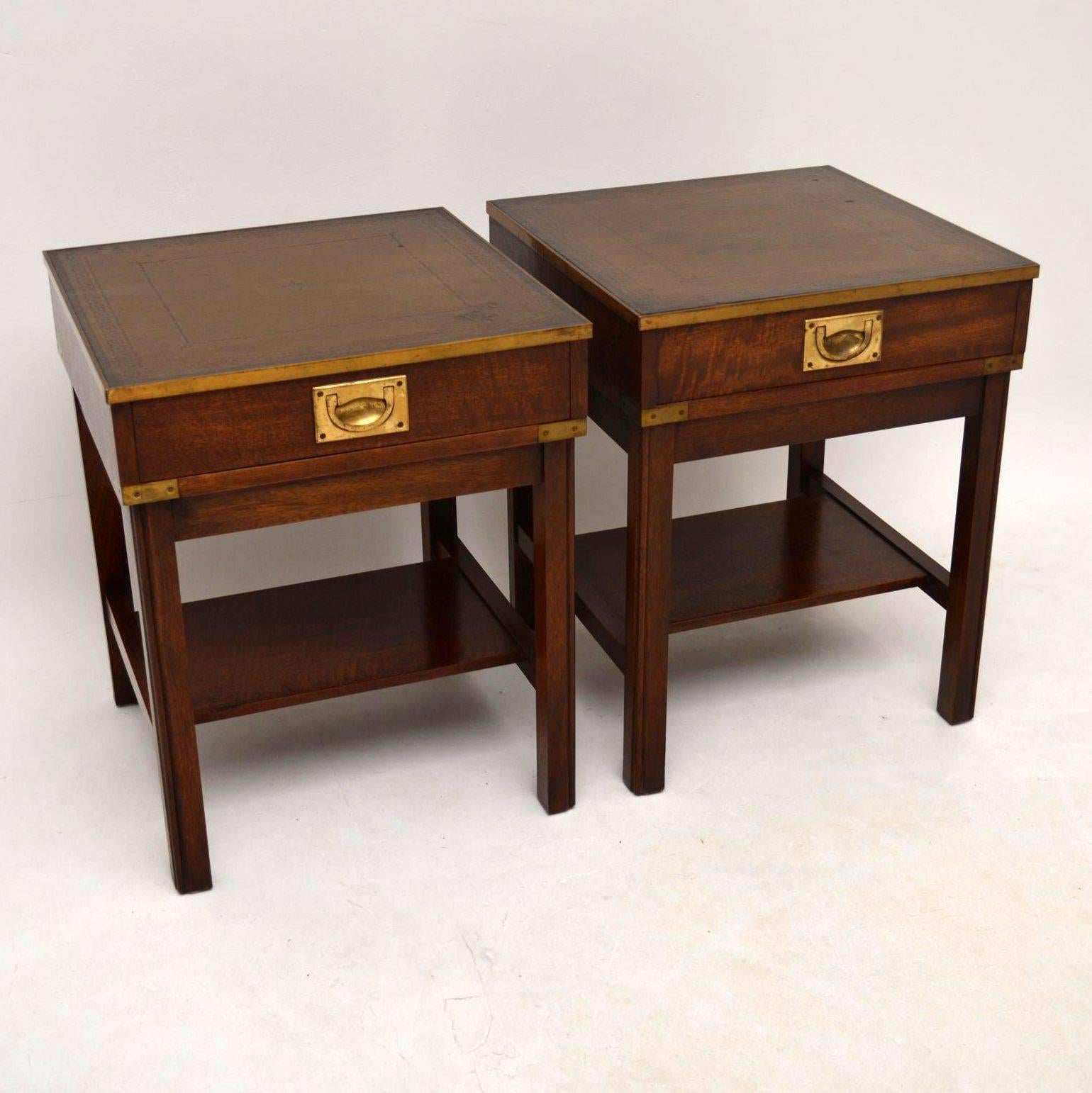 Great looking pair of mahogany side tables or even bedside tables, dating circa 1930s-1950s period. They are antique Campaign style with brass top edges, brass corners and sunken brass military handles. The brass is naturally aged, the backs are