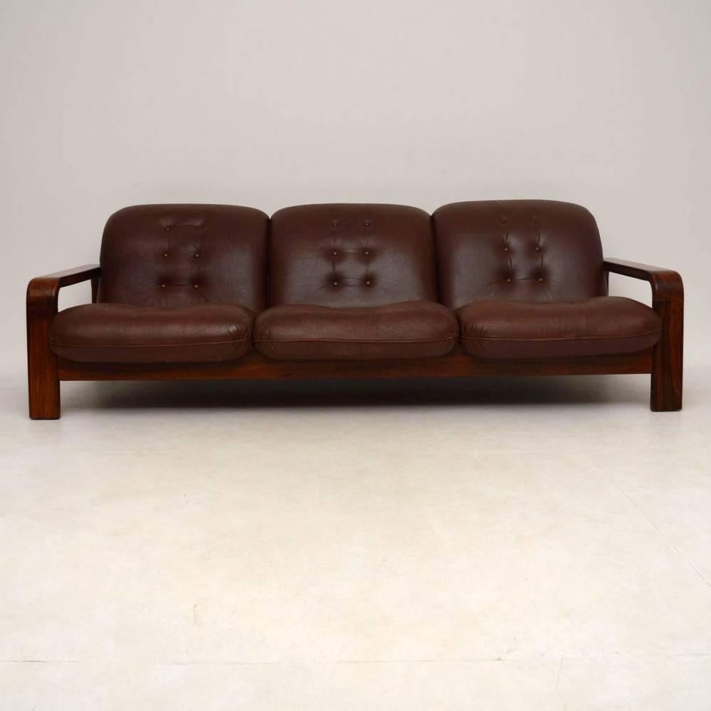 A top quality and extremely comfortable Danish sofa in solid Rosewood and brown leather upholstery. This dates from around the 1960s-1970s and it's in great condition for its age. The leather has a little wear and fade to the seat area, it's worn a