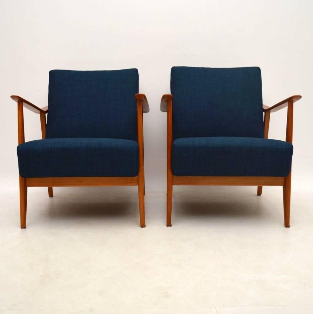 A beautifully designed and very comfortable pair of armchairs in solid cherrywood, this dates from the 1950s-1960s. We have had this stripped and re-polished to a very high standard, and the sprung cushions have been re-upholstered in our lovely
