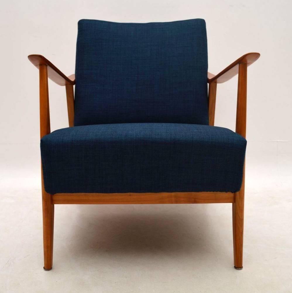 A beautifully designed and very comfortable armchair in solid cherrywood, this dates from the 1950s-1960s. We have had this stripped and re-polished to a very high standard, and the sprung cushions have been re-upholstered in our lovely midnight