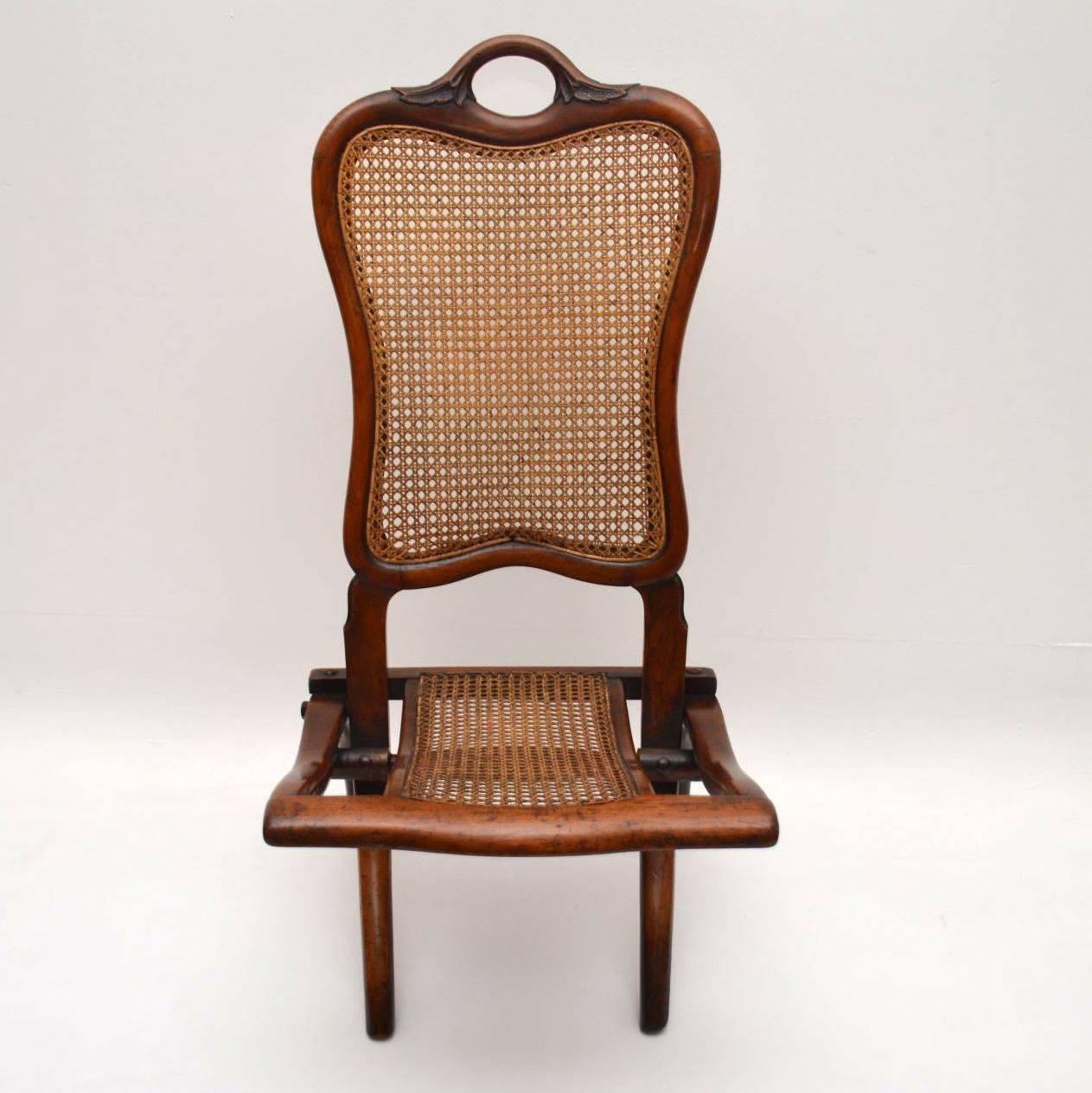 This antique Victorian mahogany and cane folding chair could have been made for use as a picnic or Campaign chair. Either way, it was definitely made for travelling purposes. It's beautifully made too, with the handle carved into the top of the