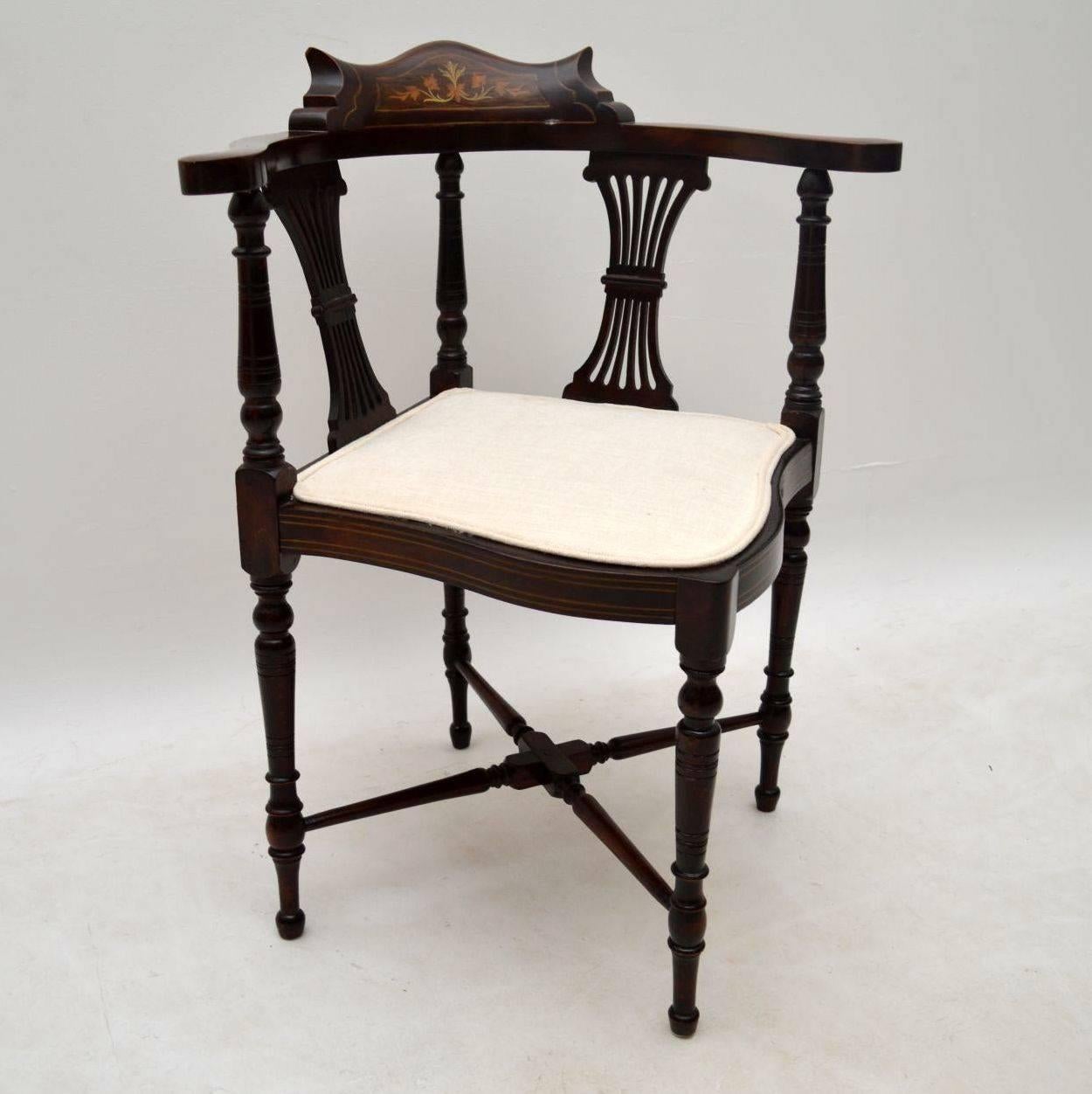 Antique Edwardian mahogany corner chair with some fine inlays of satinwood and other exotic woods. There is also some bone inlay within the top middle rosewood panel. This chair has many fine features & is well constructed. It has lyre shaped