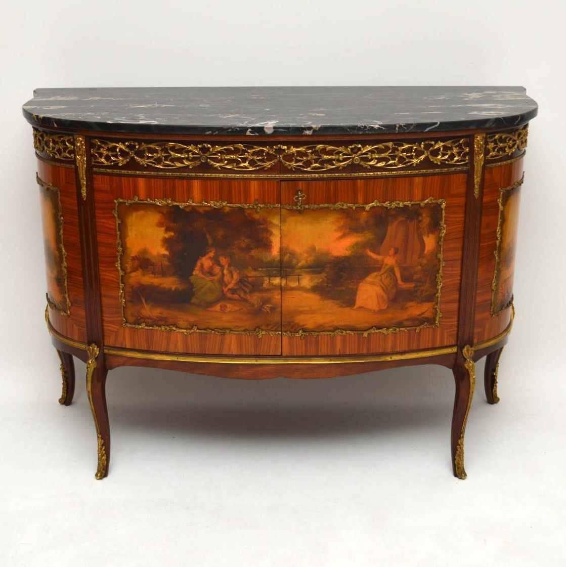 Impressive antique French marble top cabinet with very nice decorative scenes on the doors and side panels. There are lots of fine quality gilt bronze mounts and the original marble top is in good condition. The wood is predominately Kingwood &