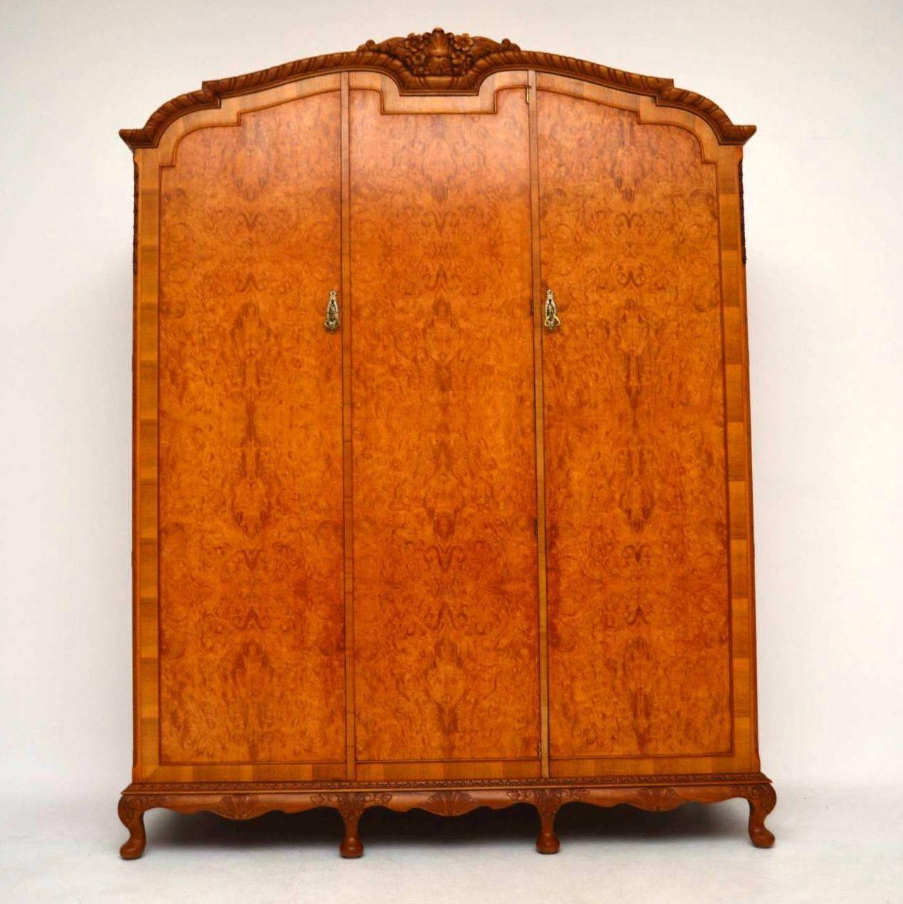 This large antique walnut wardrobe is a real stand out piece of furniture of high quality and is very practicable too. The outside is composed of three burr walnut doors sitting on a shaped carved base with carved shaped legs. The top cornice is